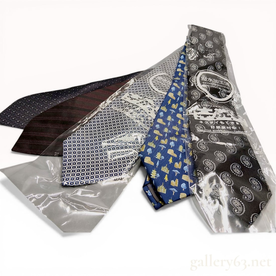 A Group of Five Designer Silk Neckties Including Salvatore Ferragamo, Hermes, and Yves Saint Laurent: This collection of five men's designer neckties is constructed from silk and features various distinctive patterns from luxury labels. Included are a blue Salvatore Ferragamo novelty architectural pri