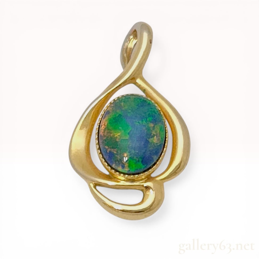 Gold-Plated Sterling Silver and Oval Cabochon Opal Teardrop Pendant: Unbranded openwork teardrop pendant featuring a central bezel-set oval cabochon opal with green and blue play-of-color. The sterling silver frame is finished with yellow gold plating and features a be