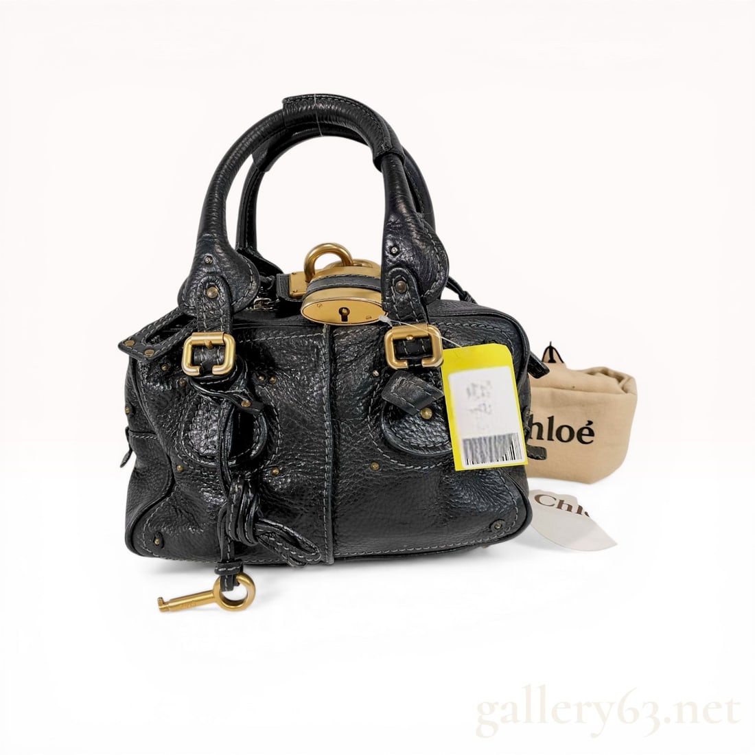 Chloe Black Grained Leather Paddington Satchel Bag: Chloé Paddington satchel in black heavy-grained leather featuring antiqued gold-tone brass hardware, circa 2005. The design includes an oversized functional padlock with a matching key, contras
