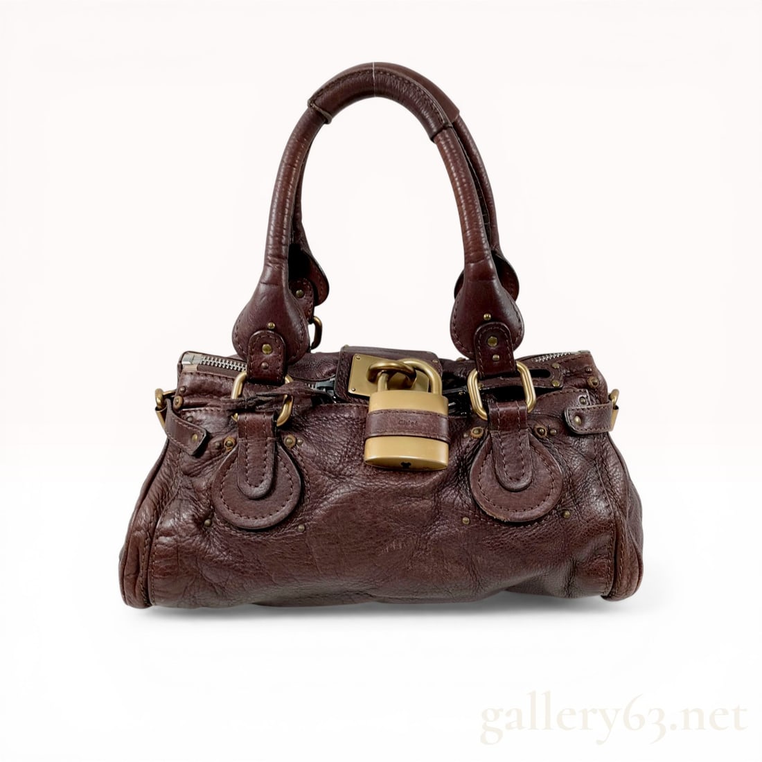 Chloe Medium Paddington Leather Satchel in Chocolate Brown: Chloé Paddington medium satchel in chocolate brown grained leather. This iconic design features dual rolled leather handles, antiqued brass-tone hardware, and the signature oversized functional