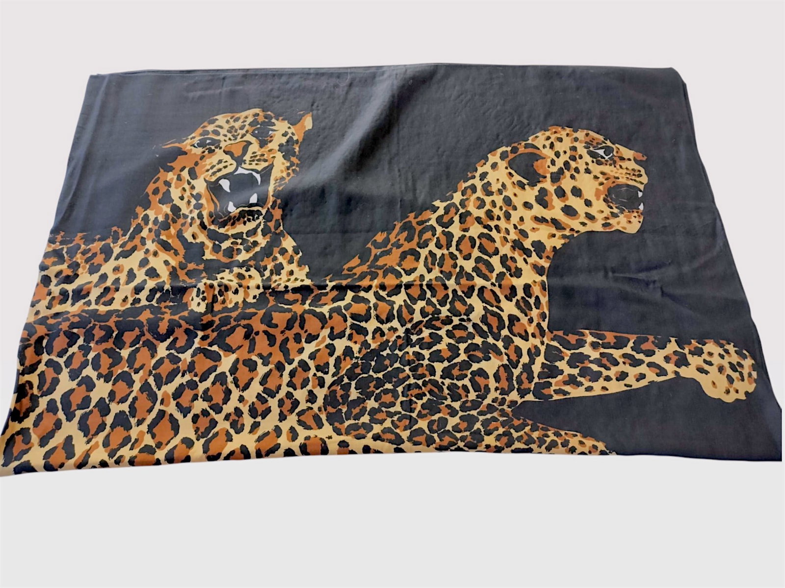 Yves Saint Laurent Leopard Print Scarf: Large Yves Saint Laurent scarf or shawl featuring a bold leopard motif, likely vintage from the late 20th century. The graphic design depicts two snarling leopard heads and leopard print in ochre and 