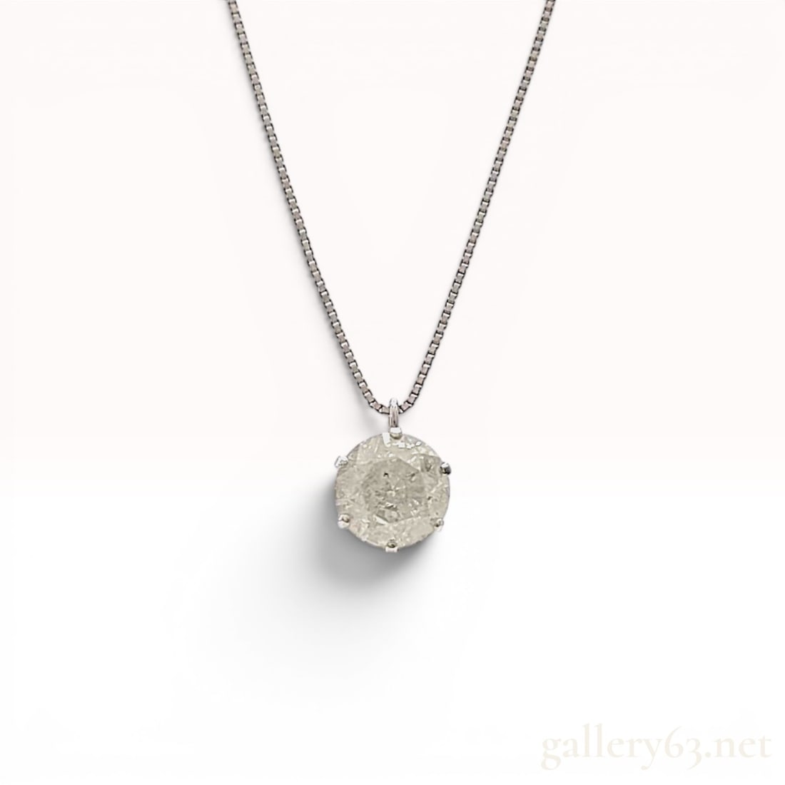 Platinum and 1.00ct Diamond Solitaire Pendant Necklace: Platinum solitaire pendant necklace featuring a round brilliant-cut diamond in a six-prong basket setting. The 1.00 carat diamond displays a translucent grey appearance with heavy natural internal inc
