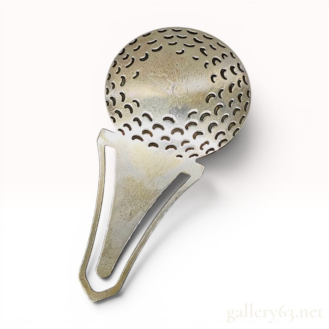 Tiffany & Co. Sterling Silver Golf Ball on Tee Bookmark and Clip: A vintage sterling silver bookmark and clip manufactured by Tiffany & Co. featuring a golf ball motif. The circular head of the piece is designed with crescent-shaped cutouts representing the dimp