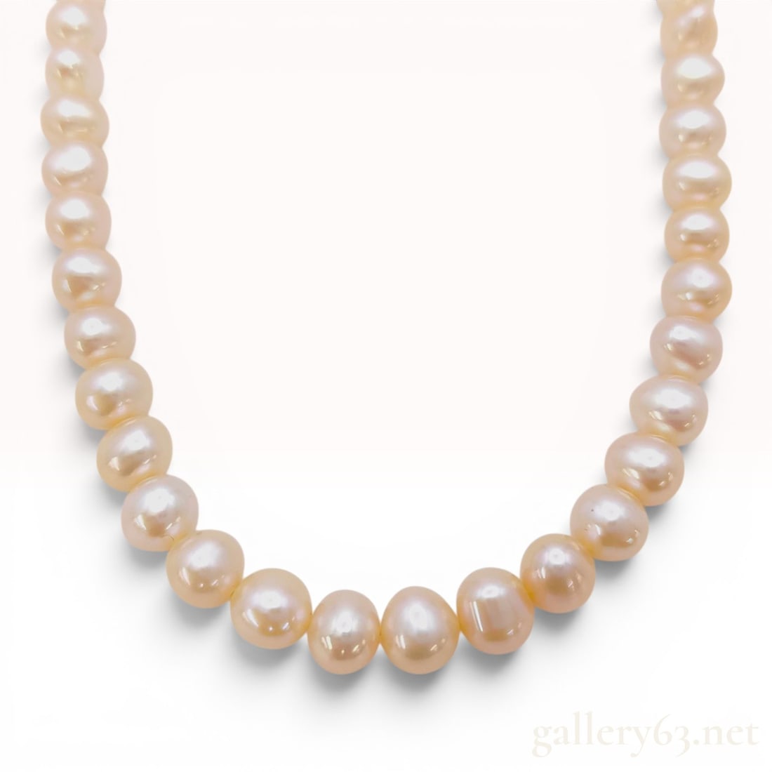 Semi-Round Pink Freshwater Cultured Pearl Necklace with Silver Clasp: A single-strand cultured freshwater pearl necklace featuring pearls with a pink to peach body color and a bright pearlescent luster. The pearls are semi-round to oval in shape with minor natural surfa