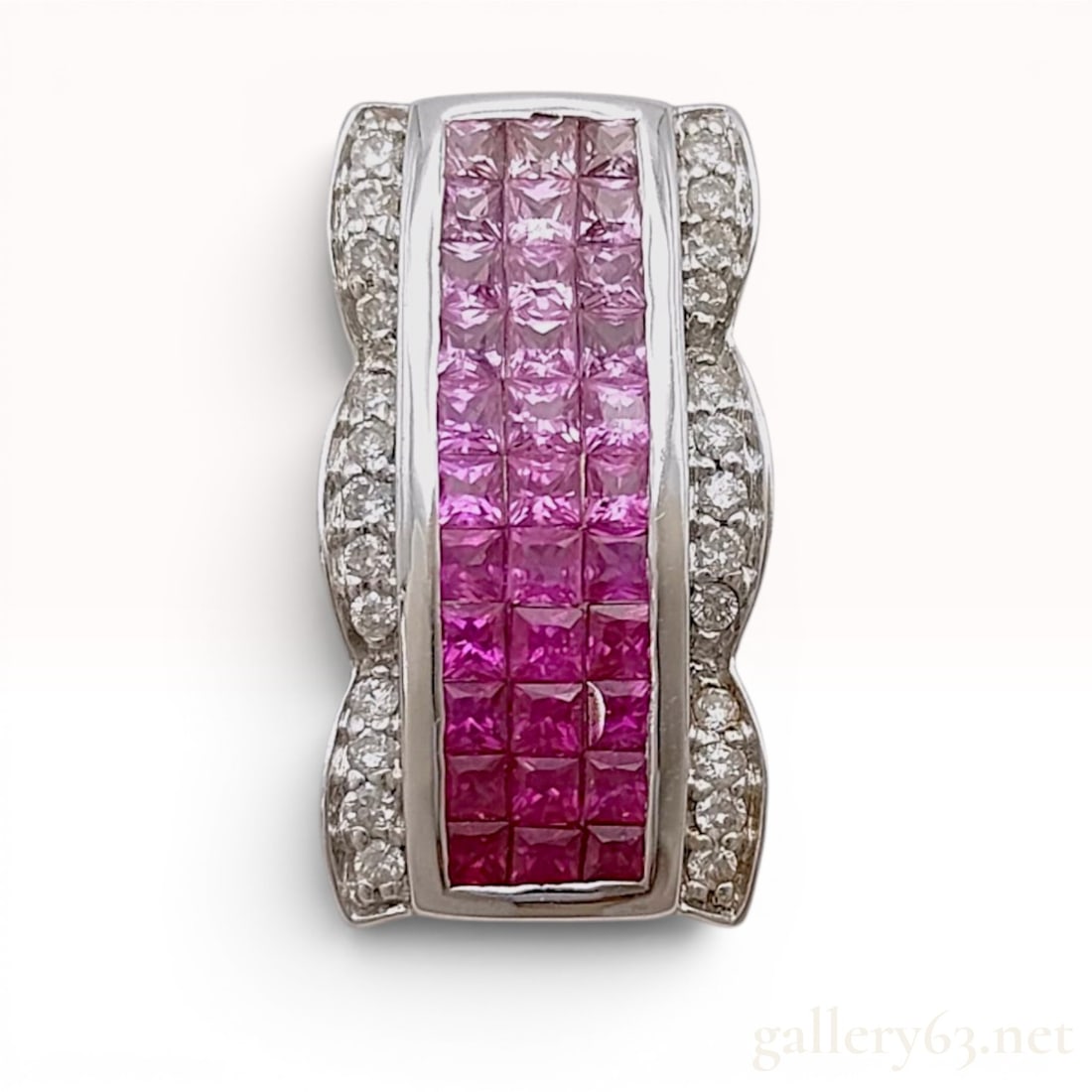 18K White Gold Ruby, Pink Sapphire, and Diamond Pendant: 18-karat white gold pendant featuring a central channel-set array of square-cut rubies and pink sapphires in a graduated color arrangement. The colored gemstones are flanked by scalloped borders grain