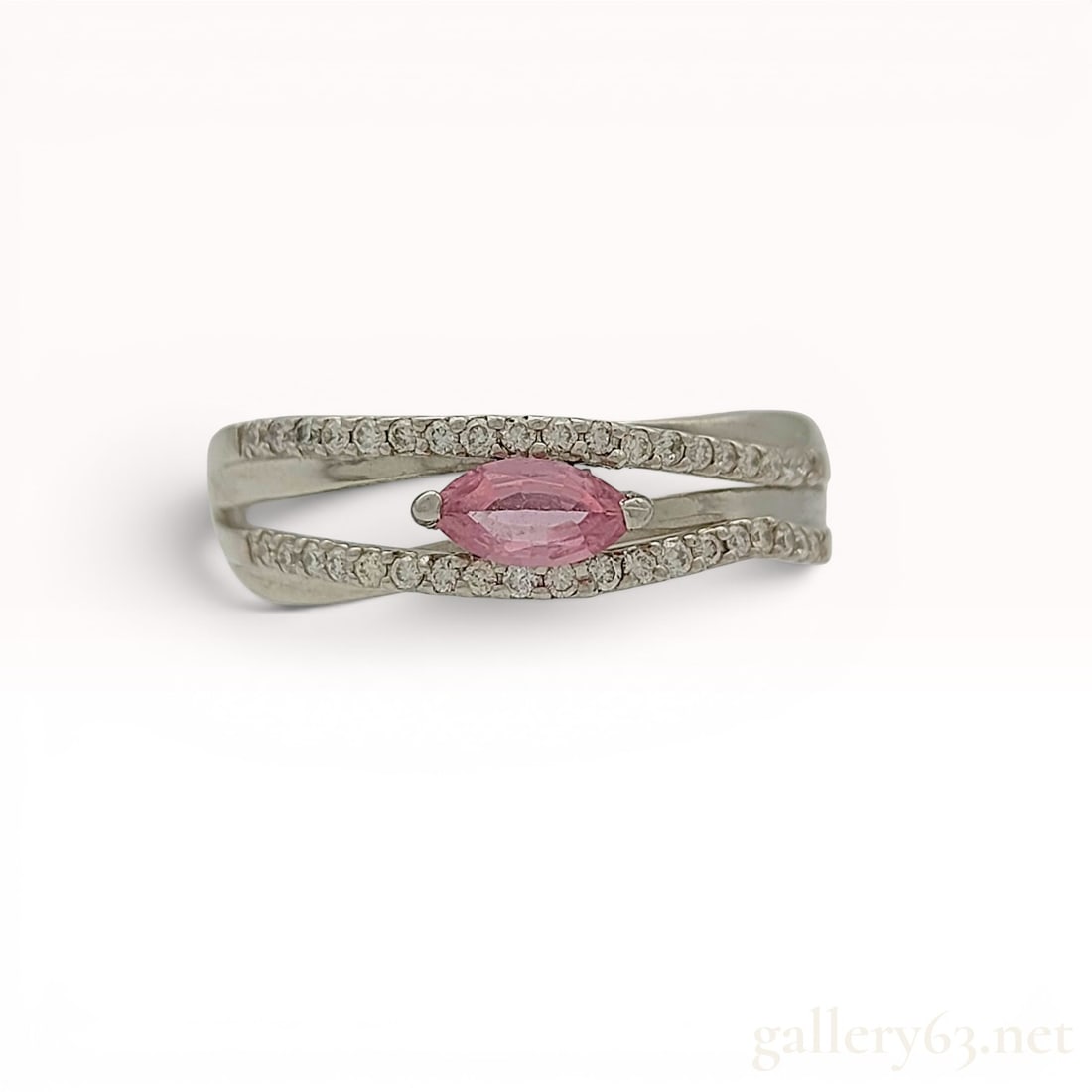 Pink Sapphire and Diamond Platinum Split Shank Ring: A platinum split-shank fashion ring featuring a central marquise-cut pink sapphire. The sapphire is secured by V-shaped prongs and set horizontally. The split-shank design is embellished with round-cu