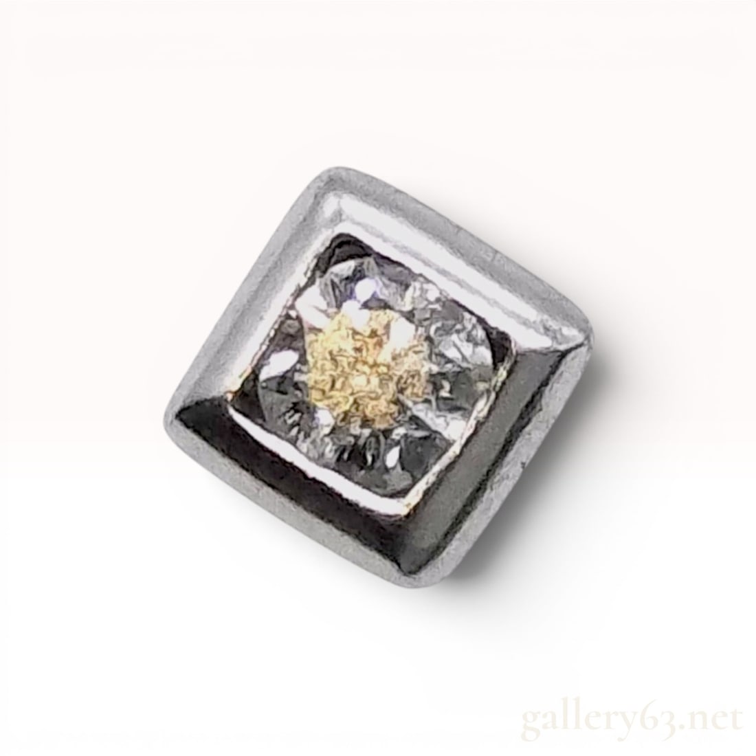 Single Platinum and Round Brilliant Cut Diamond Square Bezel Stud Earring: A single stud earring featuring a square bezel-style mounting crafted in platinum. The setting holds one round brilliant-cut diamond weighing 0.10cts. The earring post is designed for a friction back.