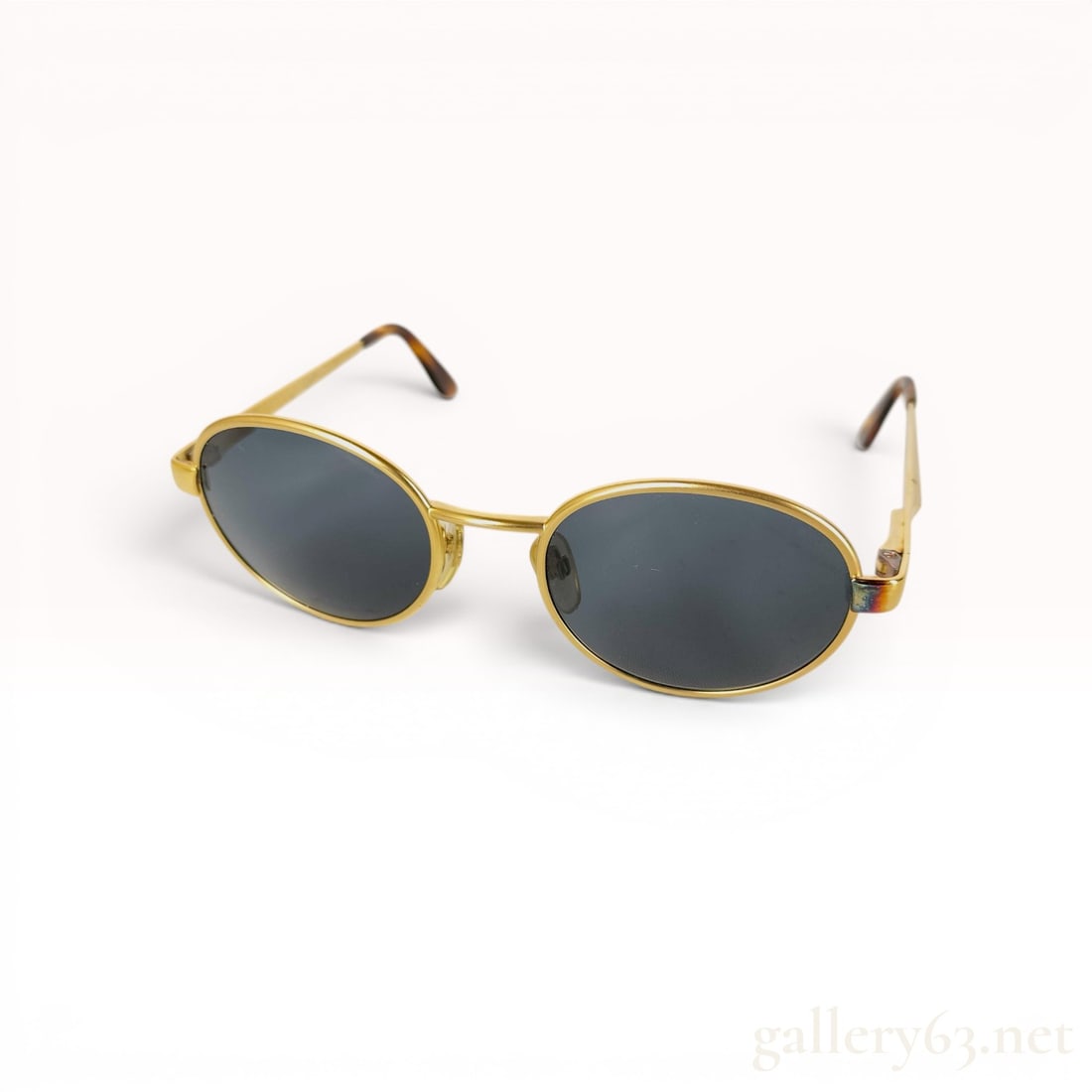 Bvlgari Model 601 Gold-Tone Metal Oval Sunglasses: Bvlgari model 601 designer sunglasses featuring gold-tone metal oval-shaped frames and dark grey tinted lenses. The frames are designed with a slim bridge and include adjustable nose pads. The gold-to