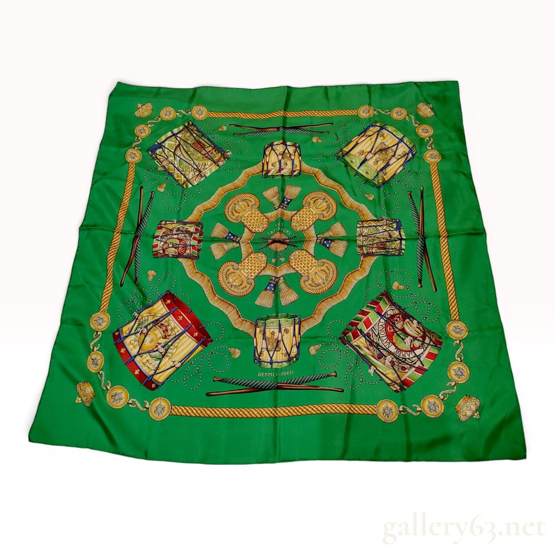 Hermes Les Tambours 90cm Silk Scarf: Hermes silk scarf in the Les Tambours pattern, originally designed by Joachim Metz in 1989. This square scarf is crafted from 100 percent silk twill in an emerald green colorway. The design features a