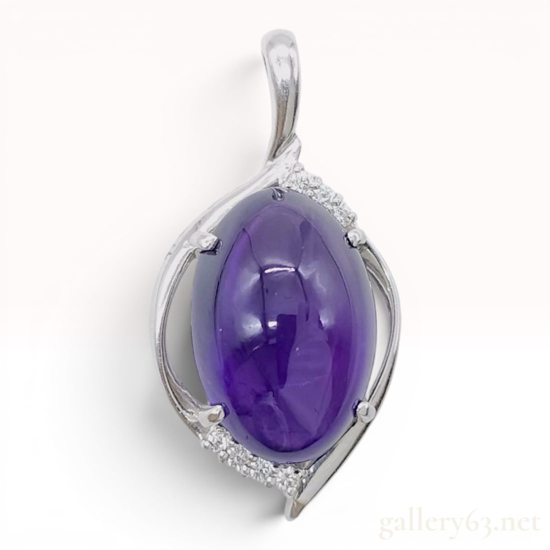 Platinum 10.85ct Amethyst and Diamond Cabochon Bypass Pendant: A contemporary platinum pendant featuring a large oval cabochon amethyst held in a four-prong setting. The central amethyst displays a deep, saturated purple color. The stone is nestled within a fluid