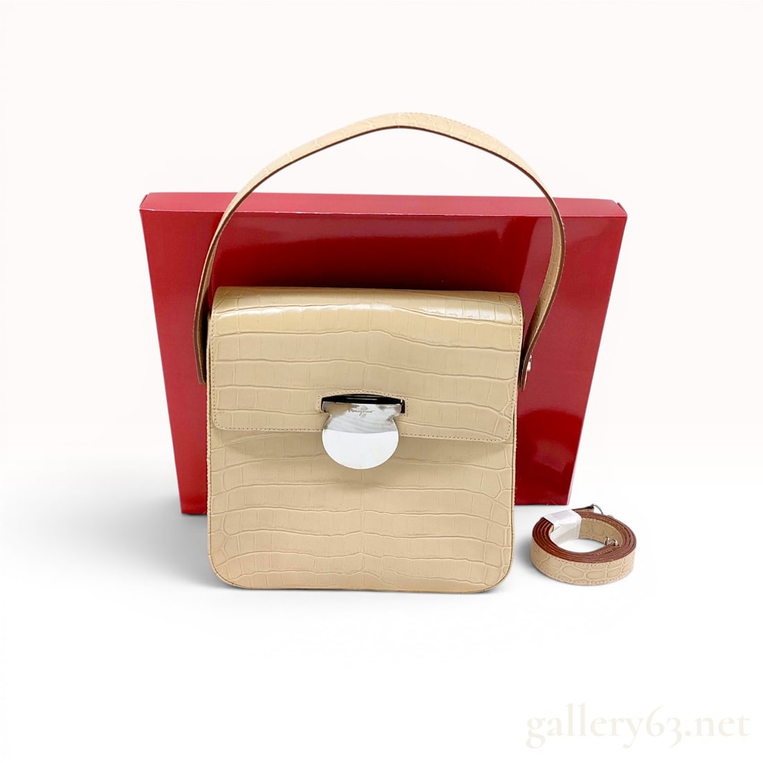 Salvatore Ferragamo Beige Crocodile Leather Structured Top Handle Bag: This structured Salvatore Ferragamo handbag is crafted from beige exotic crocodile leather, featuring a prominent rectangular scale pattern. The design includes a single top handle and a fold-over fla