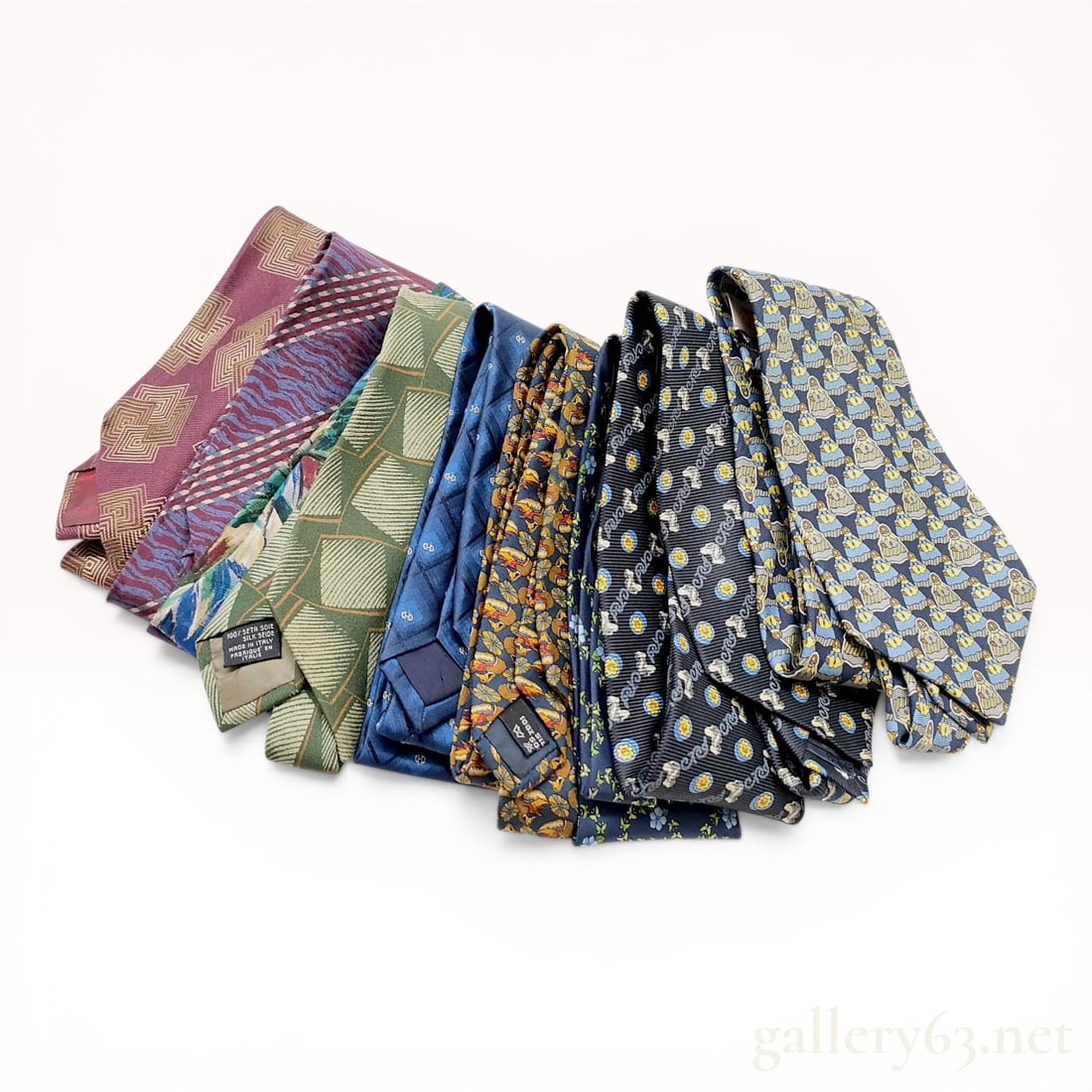 A Collection of Nine Designer Silk Neckties including Giorgio Armani, Givenchy, and Salvatore: A collection of nine designer silk neckties featuring a variety of geometric, abstract, and novelty patterns. The assortment includes three Giorgio Armani ties with geometric and striped designs, one 
