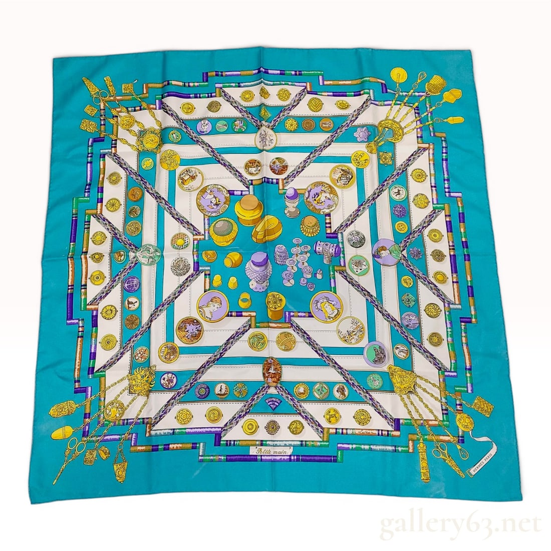 Hermes Petite Main Silk Scarf: A vintage Hermes silk twill scarf titled Petite main, first issued in 1987 and designed by Catherine Abrial. The design features a vibrant turquoise border and central field, showcasing an intricate c