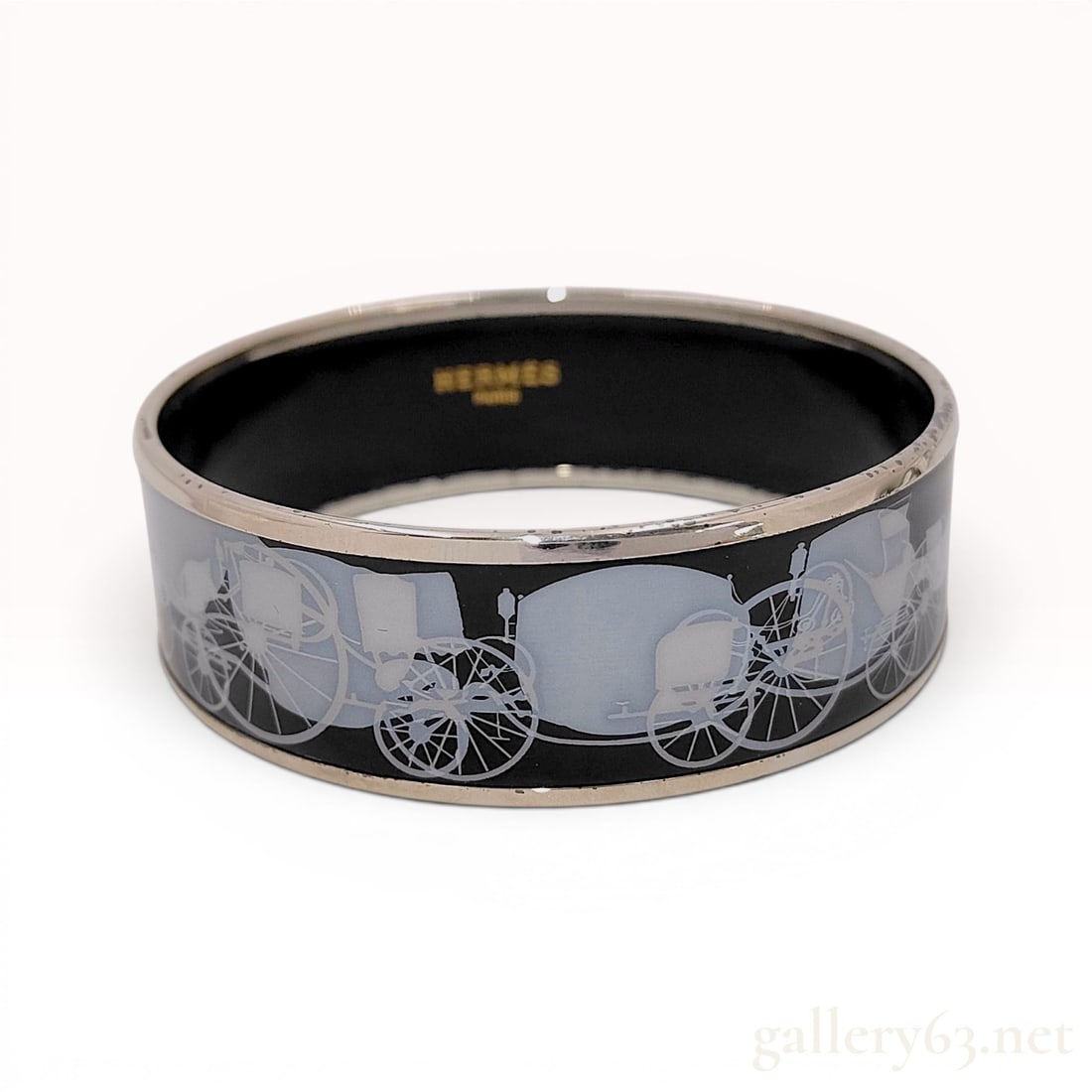 Hermes Wide Enamel Caleche Bangle Bracelet with Box: A wide enamel bangle bracelet by Hermes featuring a black enamel ground with a repeating white and grey horse-drawn carriage motif, known as the Caleche design. The enamel is set within silver-tone me