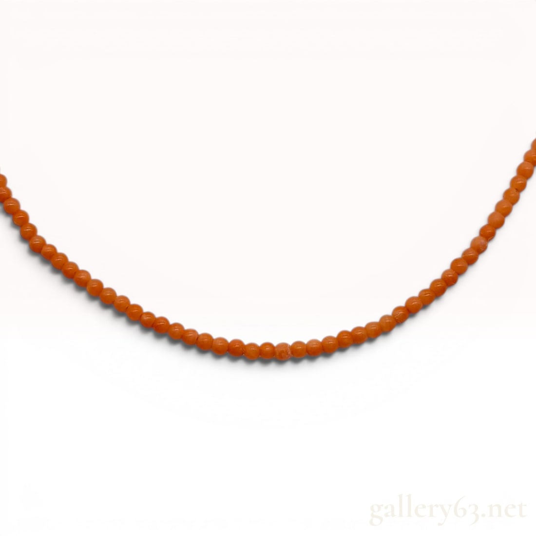 18K Yellow Gold and Natural Antique Orange Coral Beaded Necklace: A single-strand beaded necklace featuring uniform spherical antique natural orange coral beads. The beads measure approximately 2mm in diameter and display natural variations in hue and surface textur