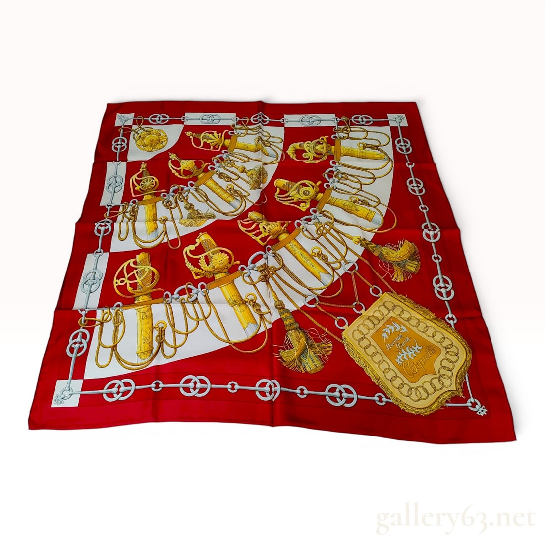Hermes Cliquetis Silk Scarf by Julia Abadie: This authentic Hermes silk scarf features the Cliquetis motif, a heritage design by Julia Abadie first introduced in 1972. The composition displays an array of ornate military sabers, swords, and tass