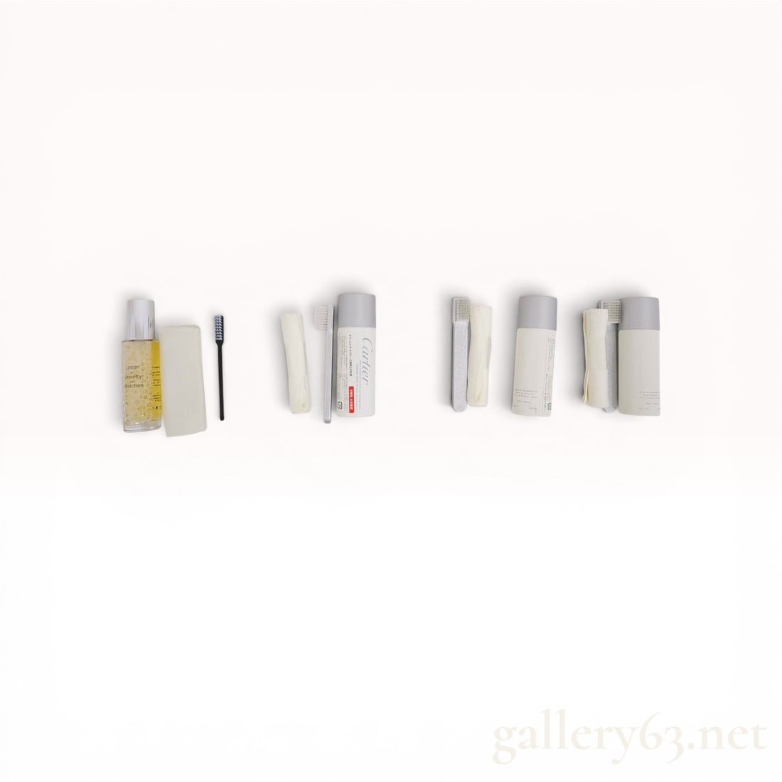 An Assortment of Cartier Watch and Jewelry Cleaning Supplies: Cartier watch and jewelry maintenance collection featuring multiple cleaning sets. The group includes three 50ml aerosol cans of Cartier cleaning spray for metal bracelets, a 30ml glass pump bottle of