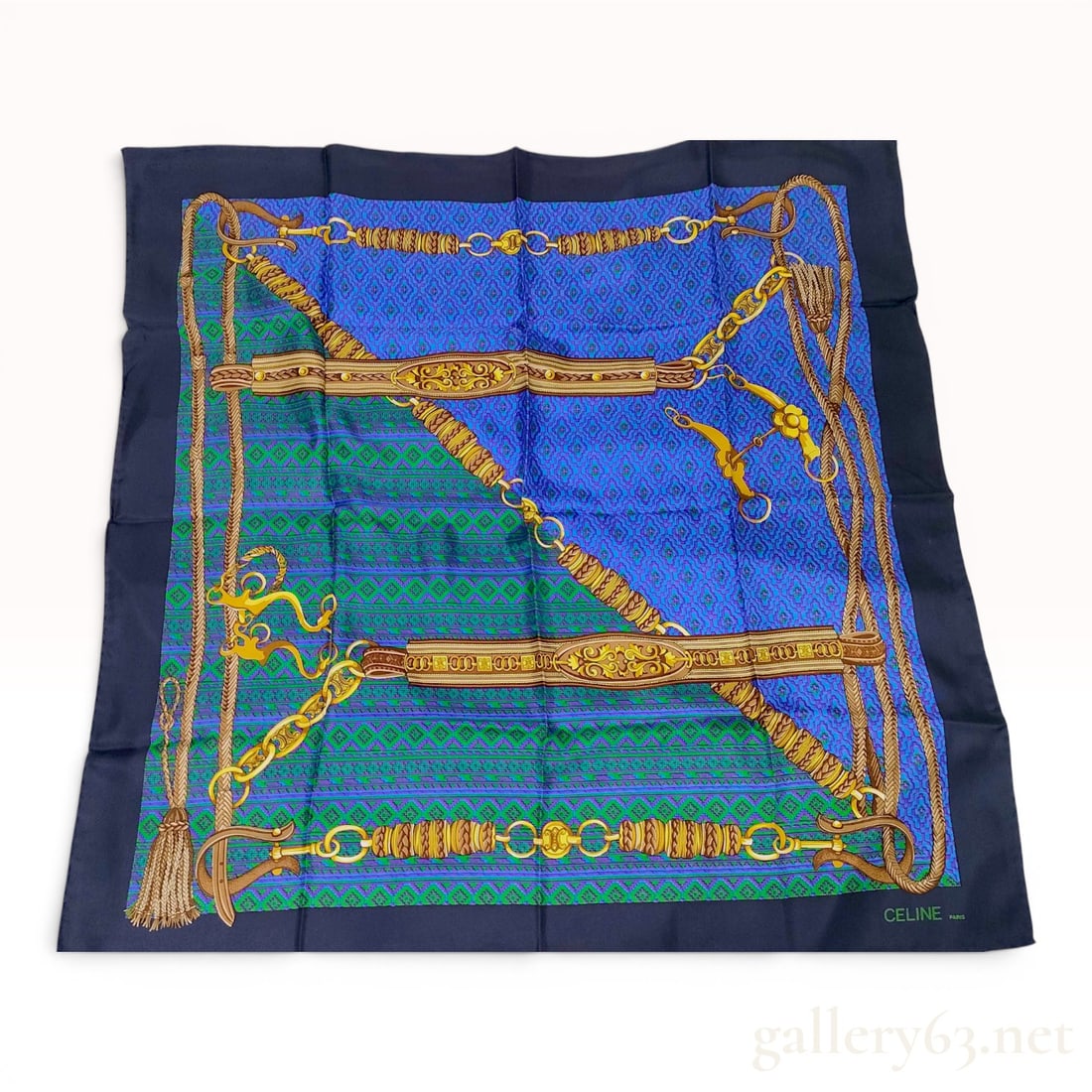 Celine Equestrian and Chain Motif Silk Scarf: This square silk scarf from Celine features an equestrian and belt-themed design. The composition includes braided ropes, leather straps with ornate gold-toned buckles, and heavy gold-link chains. Sev