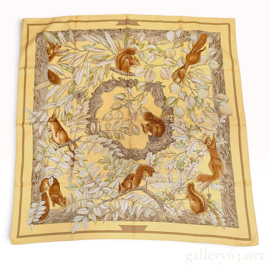 Hermes Casse Noisette 100 Percent Silk Scarf: This Hermes Paris silk scarf features the Casse Noisette pattern. The square scarf is made from 100 percent silk and features hand-rolled hems. The design depicts various squirrels positioned among de