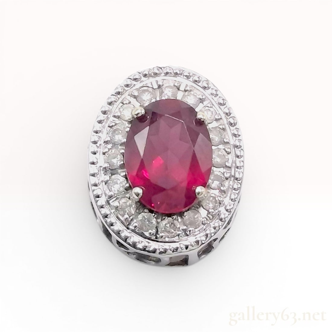 18K White Gold Halo Pendant Slide with Oval Red Tourmaline and Diamonds: Pendant slide crafted in polished 14K white gold. It features a central four-prong set oval faceted red tourmaline measuring approximately 10mm by 8mm. surrounded by a single halo of approximately eig