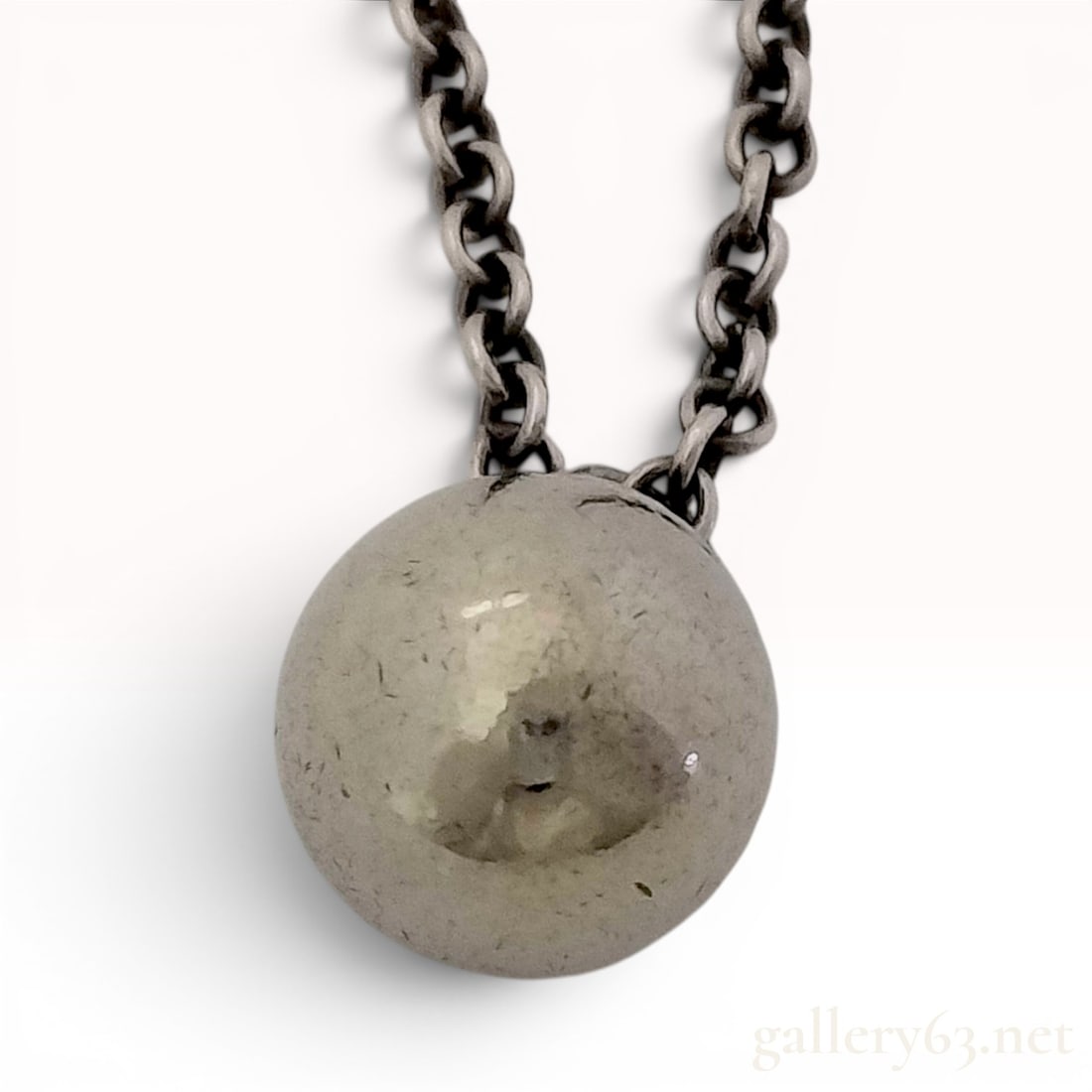 Tiffany & Co. Sterling Silver Ball Pendant Necklace: This sterling silver pendant necklace is a jewelry piece from Tiffany & Co. The design features a single polished silver ball pendant suspended from a fine cable-style chain. The pendant measures appr
