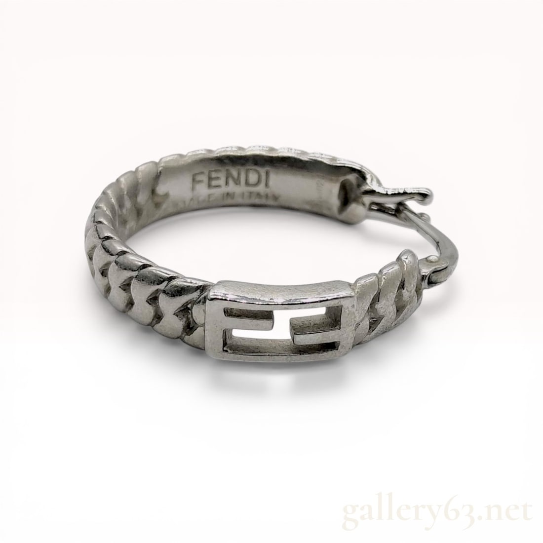Fendi Baguette FF Logo Silver-Tone Single Hoop Earring: Fendi single hoop earring from the Baguette collection, contemporary. The silver-tone metal hoop features a textured curb-link design with a central rectangular plaque displaying an open-work FF Zucca