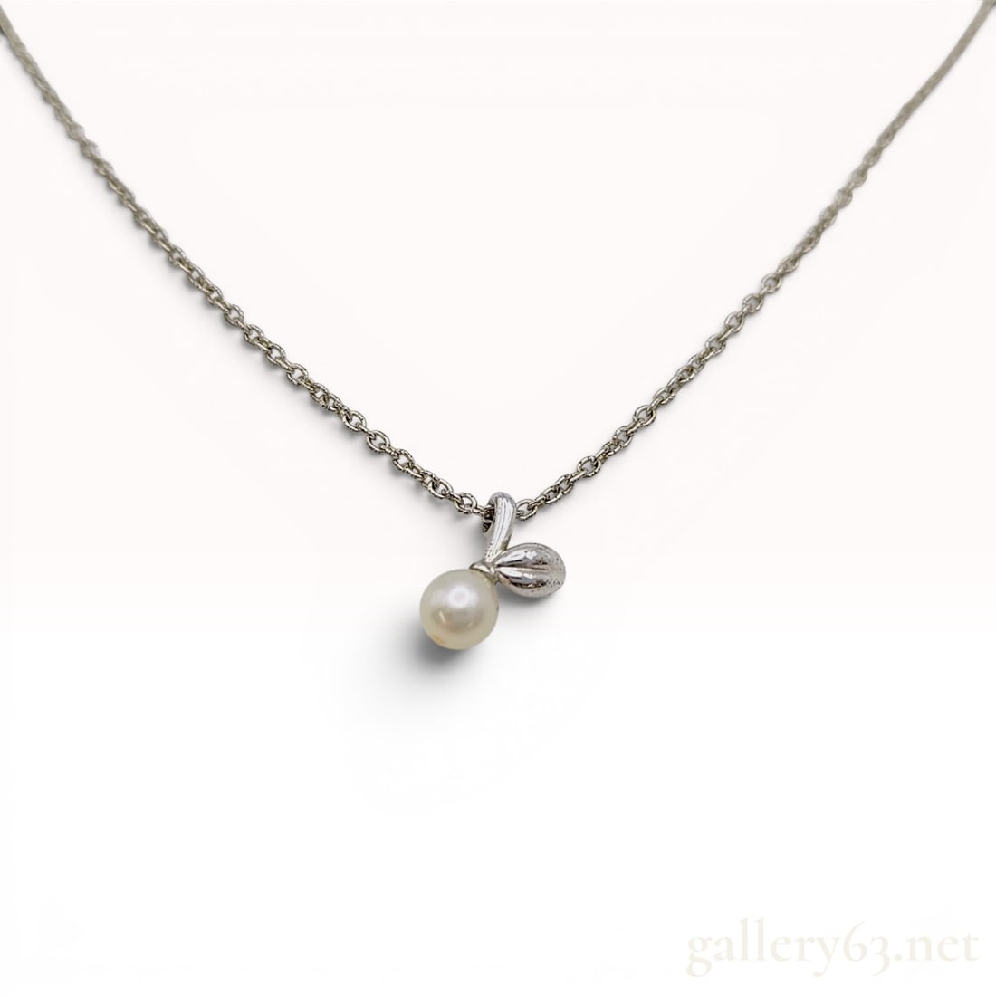 Tasaki Sterling Silver Leaf and Pearl Pendant Necklace: Tasaki sterling silver necklace featuring a stylized leaf motif and a single white cultured pearl. The pendant is suspended from a fine cable link chain with a spring ring clasp and an adjustable exte