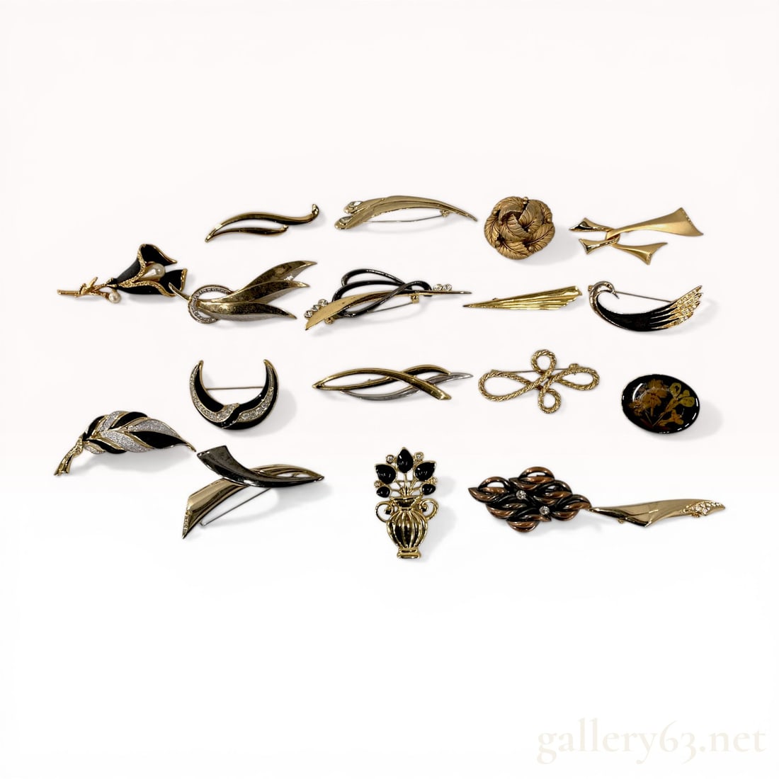 Collection of Fifteen Assorted Gold-Tone and Enamel Fashion Brooches: A collection of fifteen vintage and contemporary fashion brooches in modernist and Art Deco revival styles, late 20th century. The group features various motifs including a calla lily with faux pearls