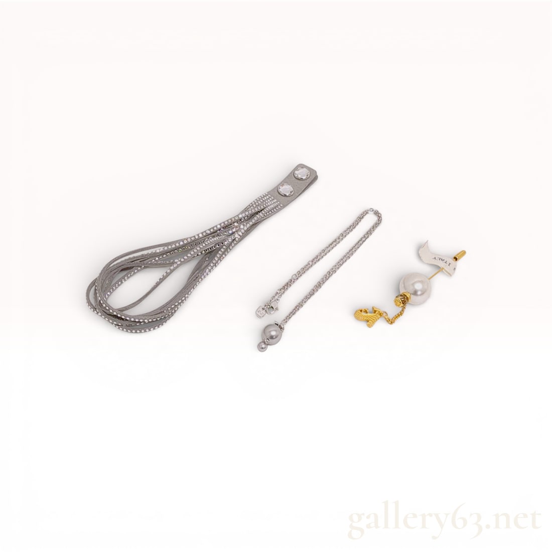 Three Swarovski and Salvatore Ferragamo Designer Jewelry Accessories: This lot consists of three contemporary designer accessories from Swarovski and Salvatore Ferragamo. The first item is a Swarovski Slake grey Alcantara wrap bracelet, model 5181989, featuring multiple