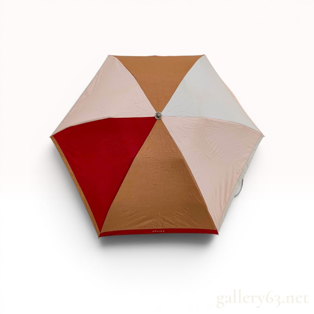 Celine Color-Blocked Folding Umbrella with Matching Sleeve: This designer folding travel umbrella is by Celine. The hexagonal canopy is composed of six color-blocked synthetic fabric panels in shades of dark red, tan, light pink, and light gray. Each panel is 