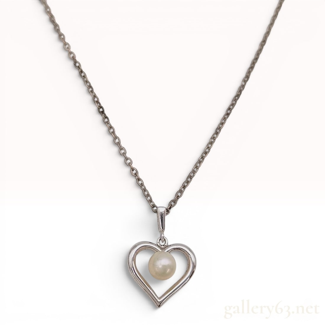 Mikimoto Sterling Silver and Akoya Cultured Pearl Heart Pendant Necklace: This Mikimoto pendant necklace is crafted in sterling silver and features an Akoya cultured pearl. The open heart-shaped pendant frame houses a single cream-colored spherical cultured pearl at its cen