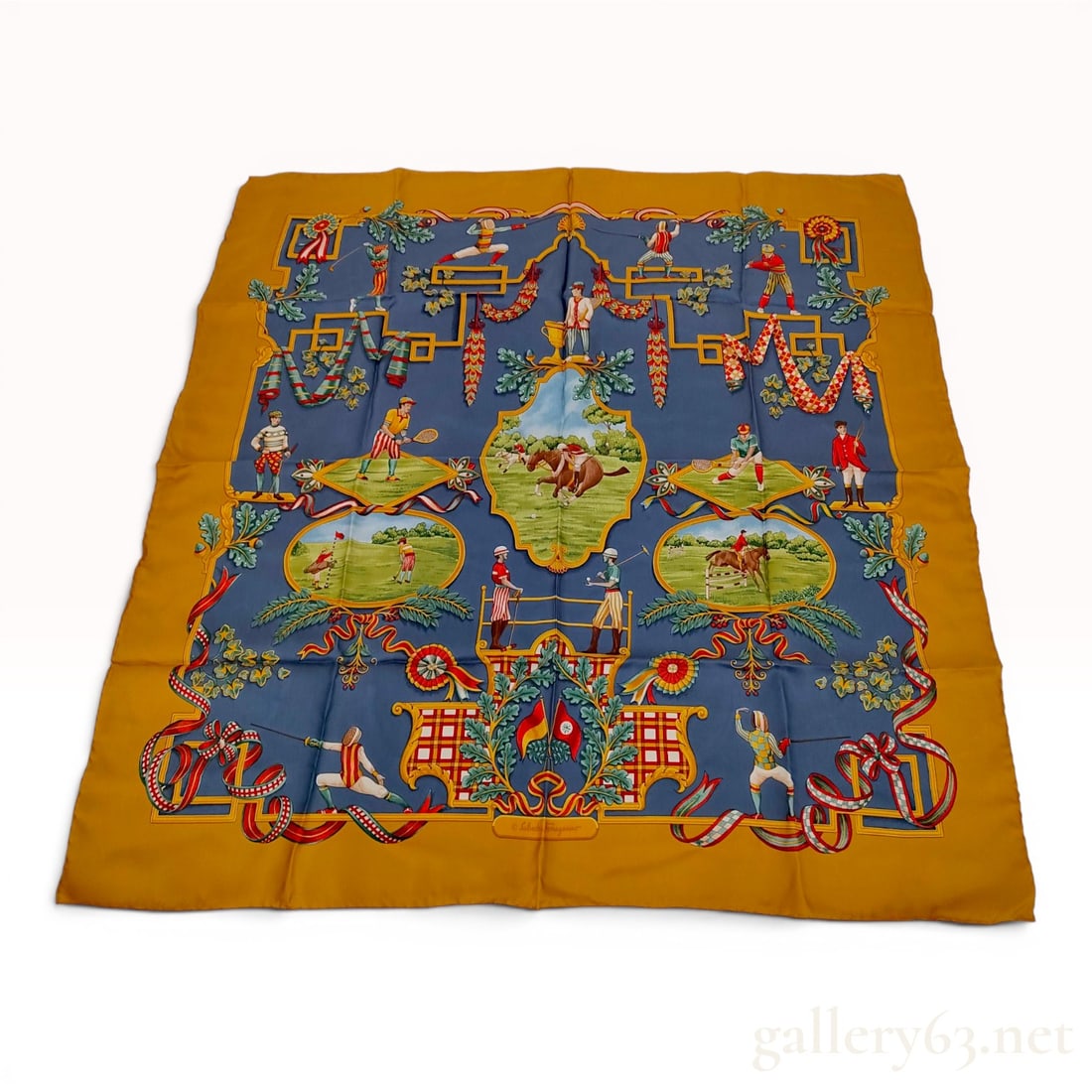 Salvatore Ferragamo Silk Twill Scarf with Sporting and Equestrian Theme: This Salvatore Ferragamo square scarf is crafted from 100 percent silk twill with hand-rolled edges. The design features a slate blue central field decorated with various sporting vignettes, including