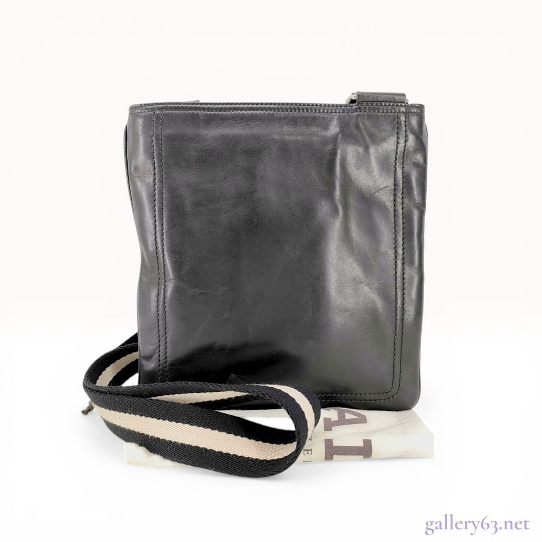 Bally Black Leather Trainspotting Messenger Bag: Bally crossbody messenger bag from the Trainspotting collection. Crafted from black leather featuring a signature black and cream striped woven canvas strap and silver-tone hardware. The interior is l