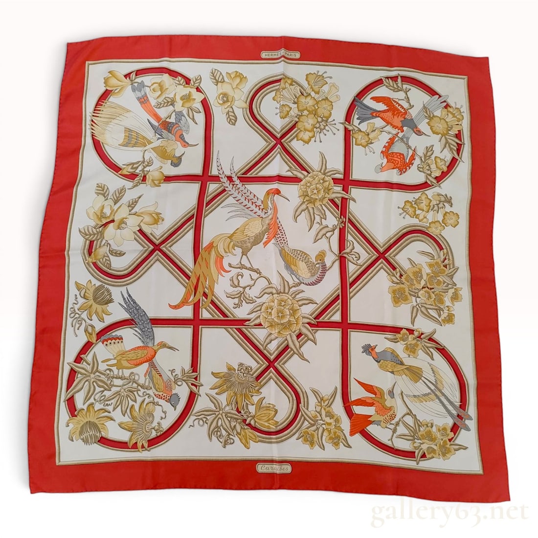 Hermes Silk Caraibes Scarf designed by Christiane Vauzelles: This silk twill scarf from Hermes features the Caraibes pattern, created by artist Christiane Vauzelles. The design centers on tropical birds and botanical elements including magnolias and passionflow