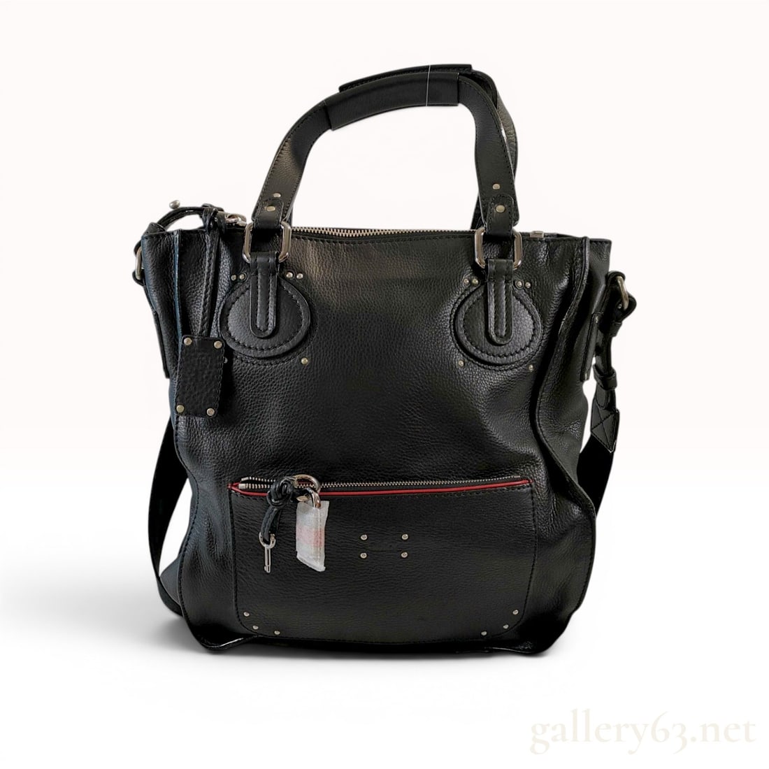 Chloe Black Pebbled Leather Paddington Tote Bag: Chloe Paddington tote bag in black pebbled calfskin leather with oversized silver-tone hardware. Features dual rolled leather top handles, circular leather overlays with decorative studs, and a detach
