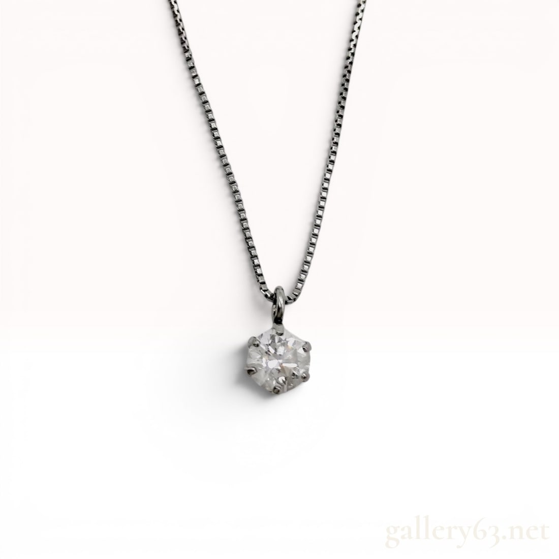 Platinum and Diamond Solitaire Pendant Necklace: This diamond solitaire pendant necklace features a round brilliant-cut diamond set in platinum. The gemstone is secured within a six-prong setting. The reverse of the pendant setting is stamped Pt900,