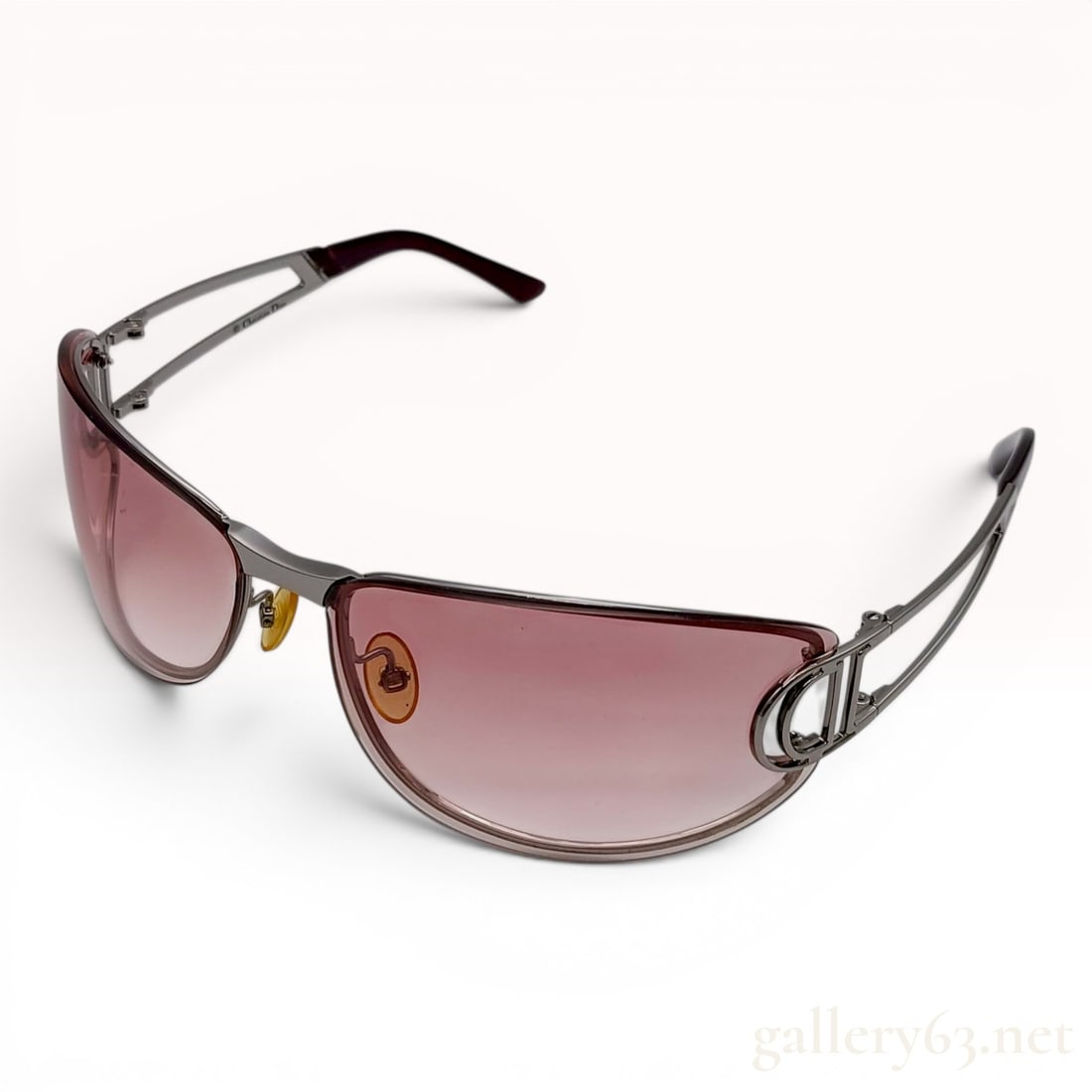 Christian Dior Diorissimo/F Gunmetal and Burgundy Gradient Sunglasses: A pair of Christian Dior Diorissimo/F designer sunglasses featuring a semi-rimless wrap-around design. The frames are constructed from a dark gunmetal silver-tone metal with curved lenses. The lenses 