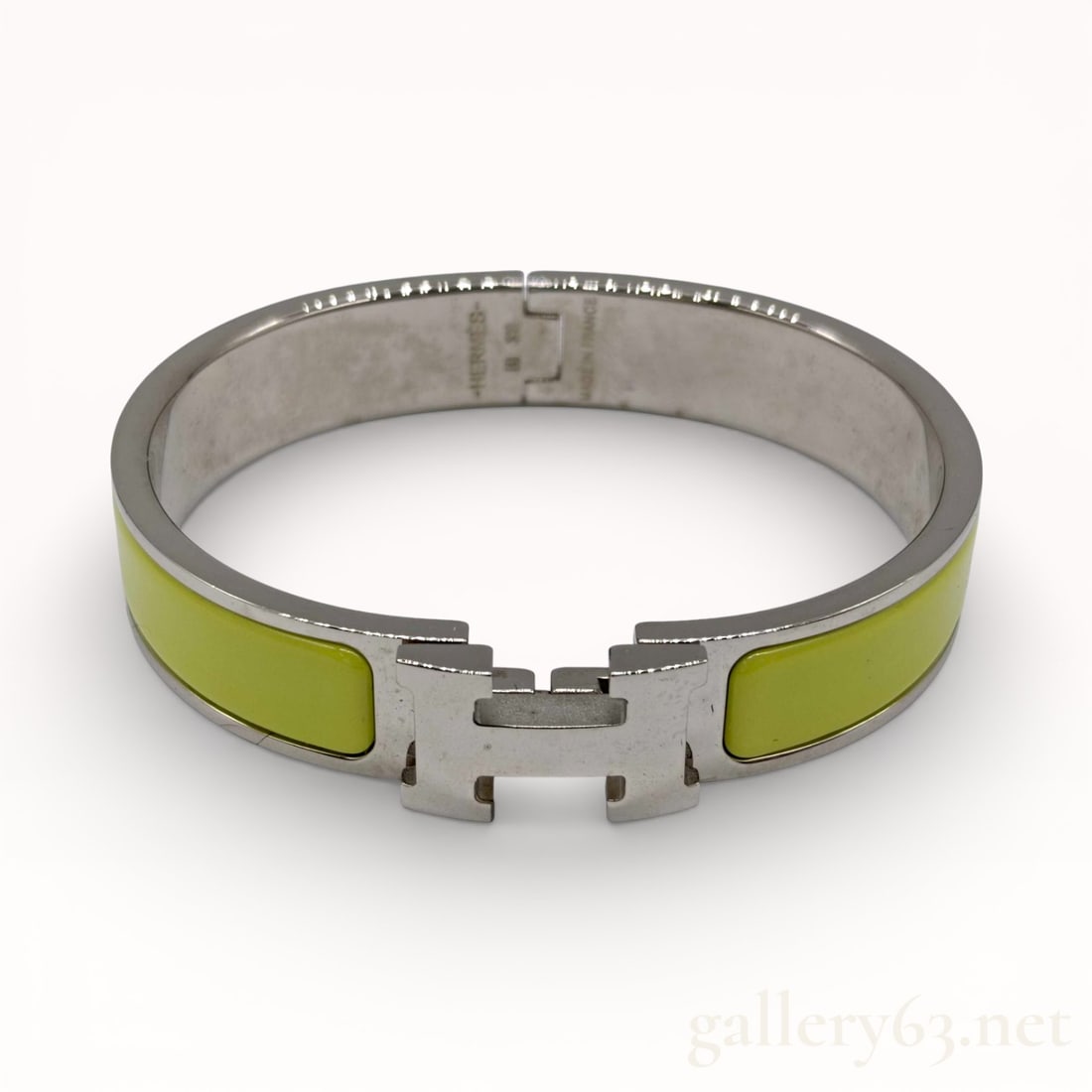 Hermes Clic H bracelet in citron yellow enamel and palladium-plated metal: Authentic Hermes bangle bracelet having a silver-tone metal frame set with green enamel panels on each side. Iconic H-shaped clasp integrated at front, forming the central closure. Interior showing en