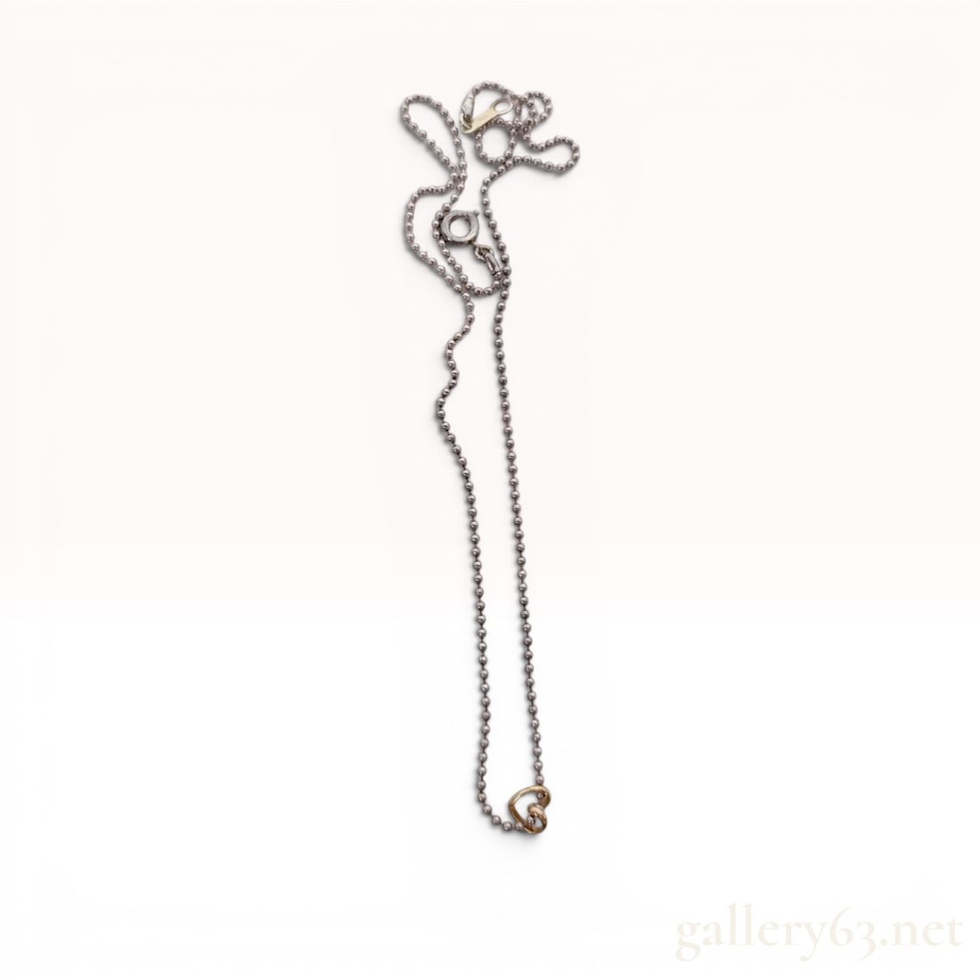 4C Silver & 10K Gold Interlocking Heart Pendant Necklace: 4â„? silver pendant necklace featuring a contemporary interlocking heart design. The piece is composed of a silver ball chain and two small, interlocking open-heart charms in silver and gold-toned 