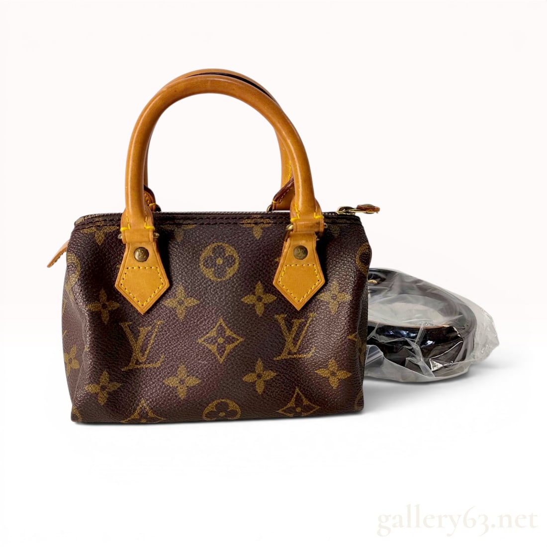 Louis Vuitton Monogram Canvas Mini HL Speedy Handbag: A Louis Vuitton Mini HL Speedy handbag featuring the brand signature brown monogram coated canvas with vachetta leather trim and dual rolled leather top handles. The bag is constructed with gold-tone 