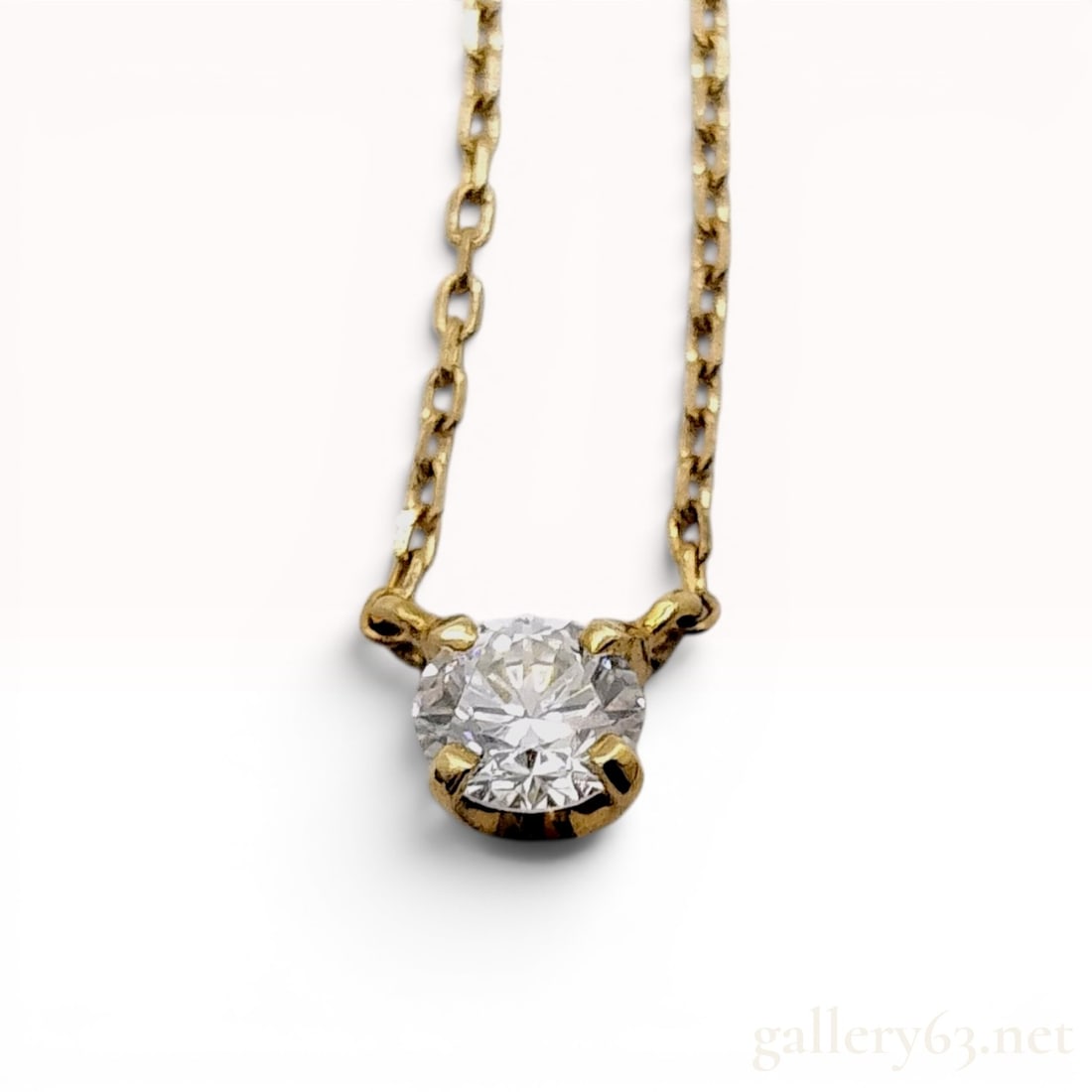 18 Karat Yellow Gold and 0.10 Carat Diamond Solitaire Pendant Necklace: This solitaire pendant necklace is crafted in 18 karat yellow gold. It features a single round brilliant cut diamond secured in a four-prong setting. The pendant is stationary on a fine cable link cha