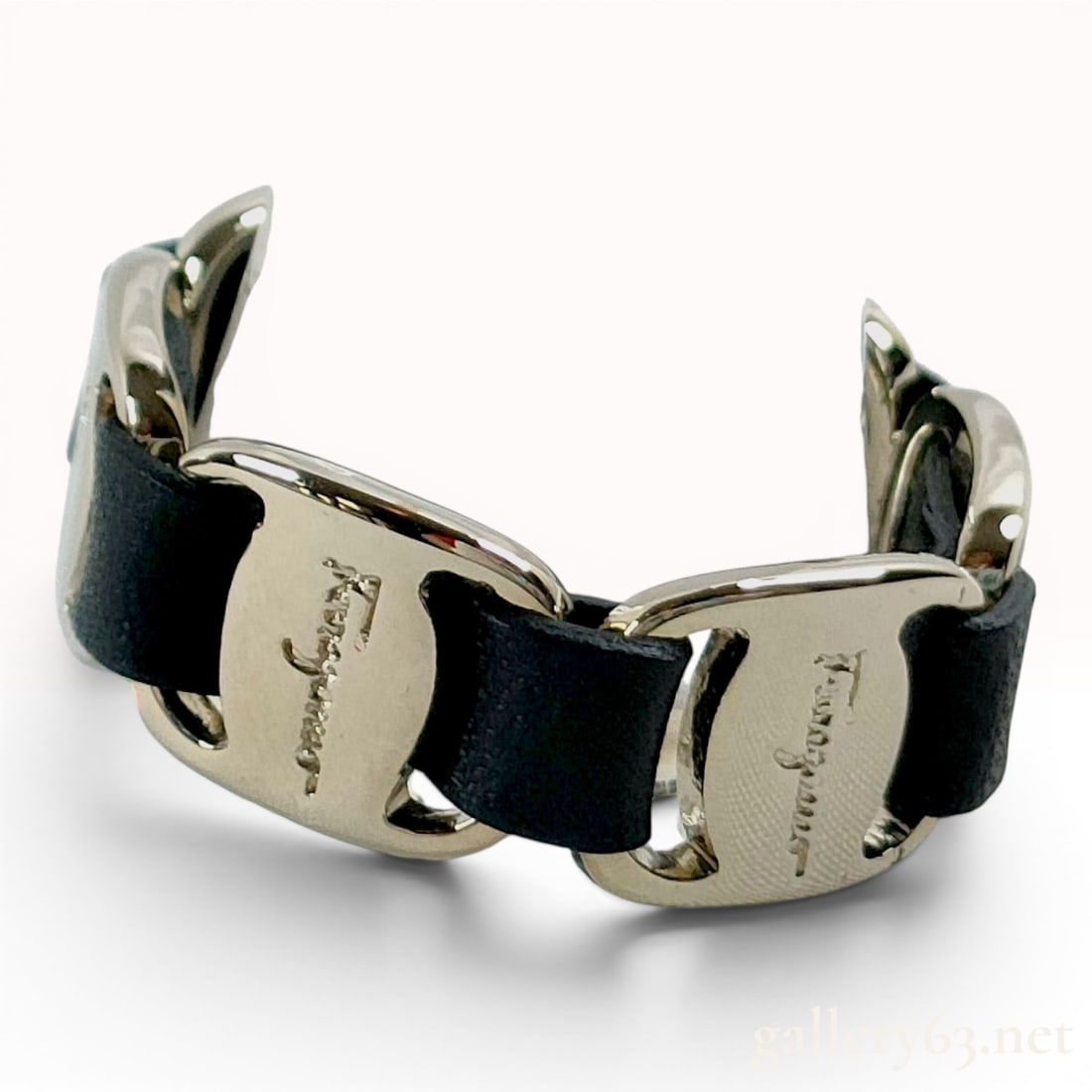 Salvatore Ferragamo Silver-Toned and Black Leather Band Scarf Ring: A designer band ring by Salvatore Ferragamo featuring a woven construction. The ring is composed of multiple silver-toned metal links with strips of black leather woven through the central apertures, 