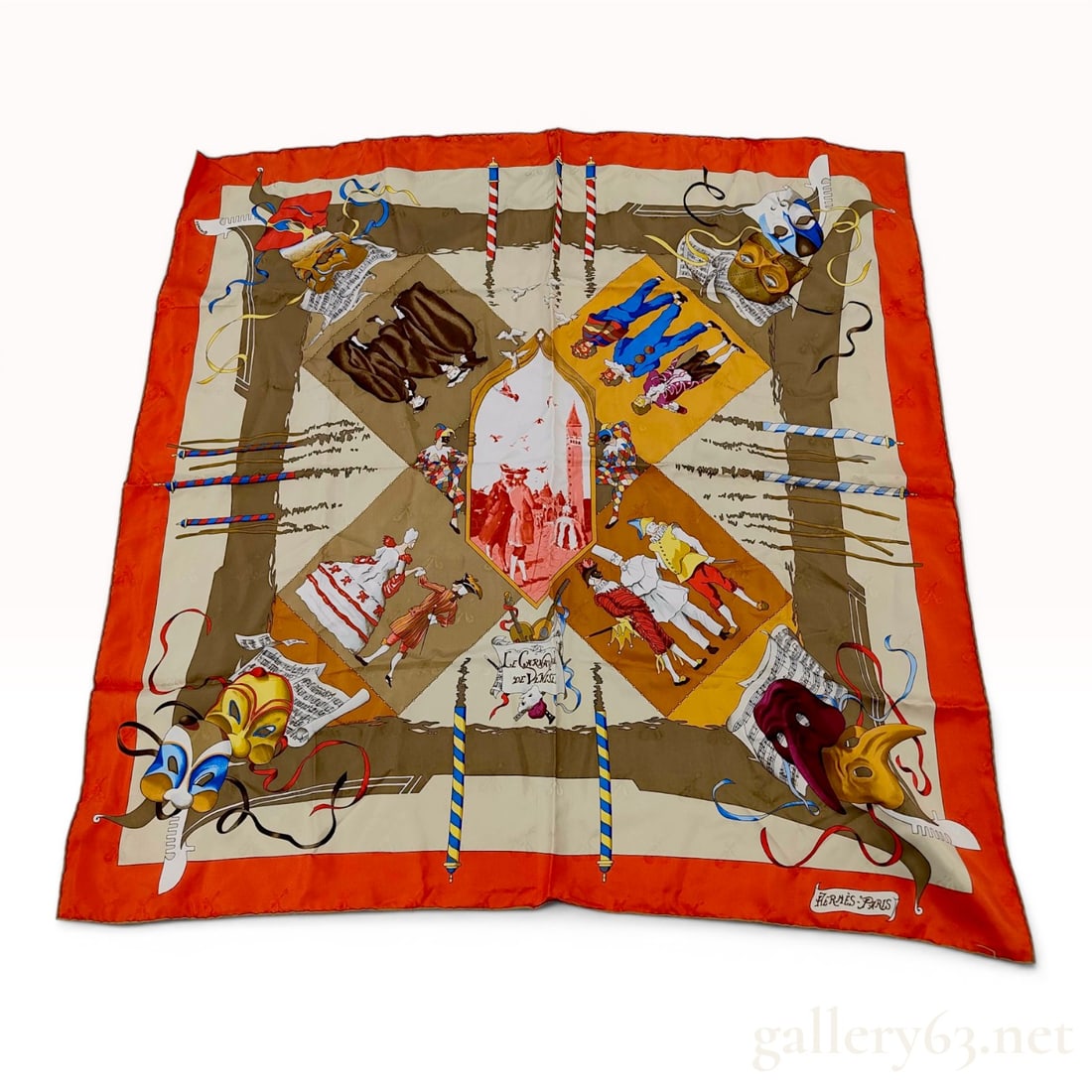 Hermes Le Carnaval de Venise Jacquard Silk Scarf: Hermes silk twill scarf titled Le Carnaval de Venise, designed by artist Hubert de Watrigant and originally issued in 1993. The scarf features a wide orange border framing a central vignette of the Pi