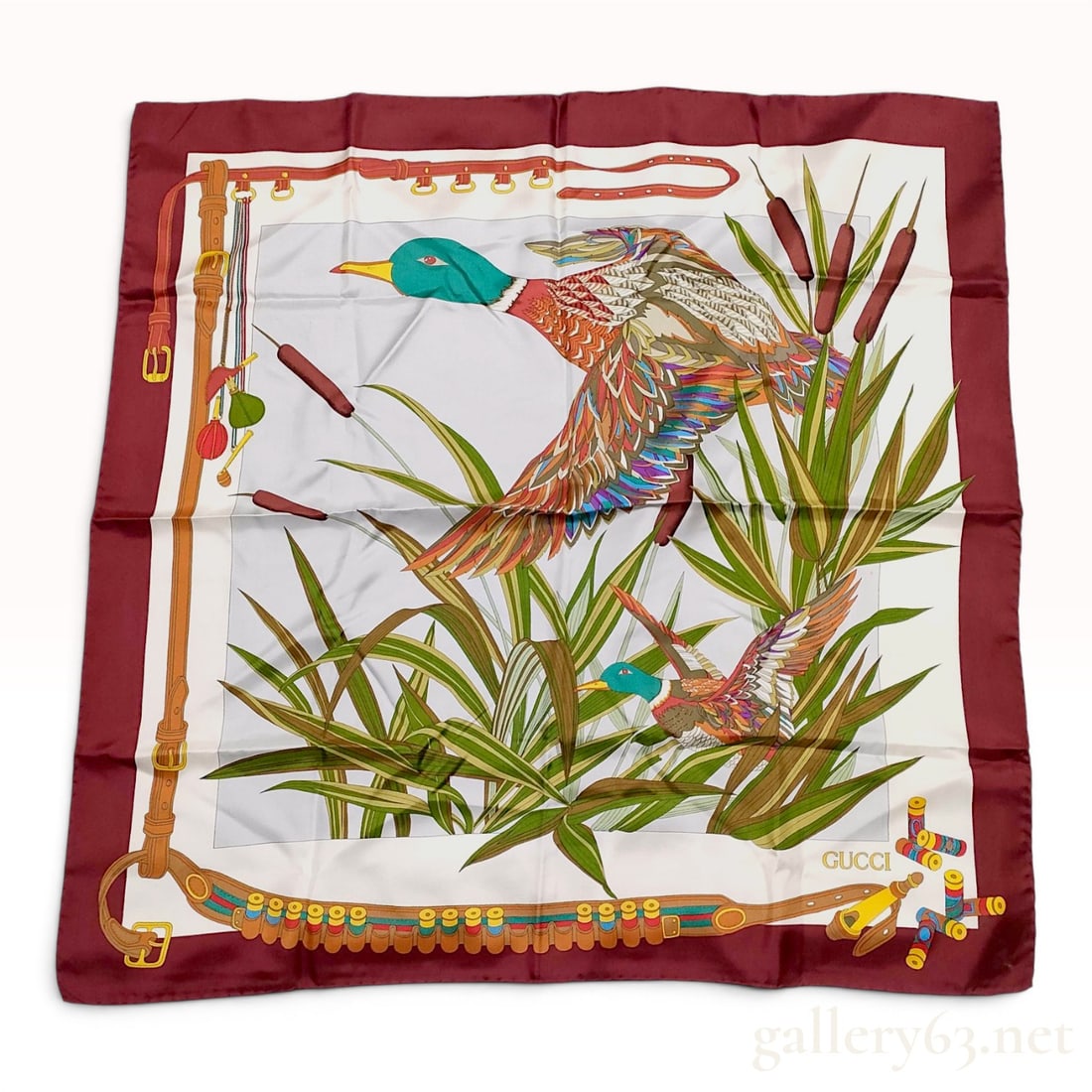 Vintage Gucci Silk Scarf with Waterfowl Hunting Motif: A vintage Gucci silk twill scarf featuring a sporting hunting theme. The central white field depicts two mallard ducks in flight amidst green reeds and brown cattails. A border motif illustrates a bro
