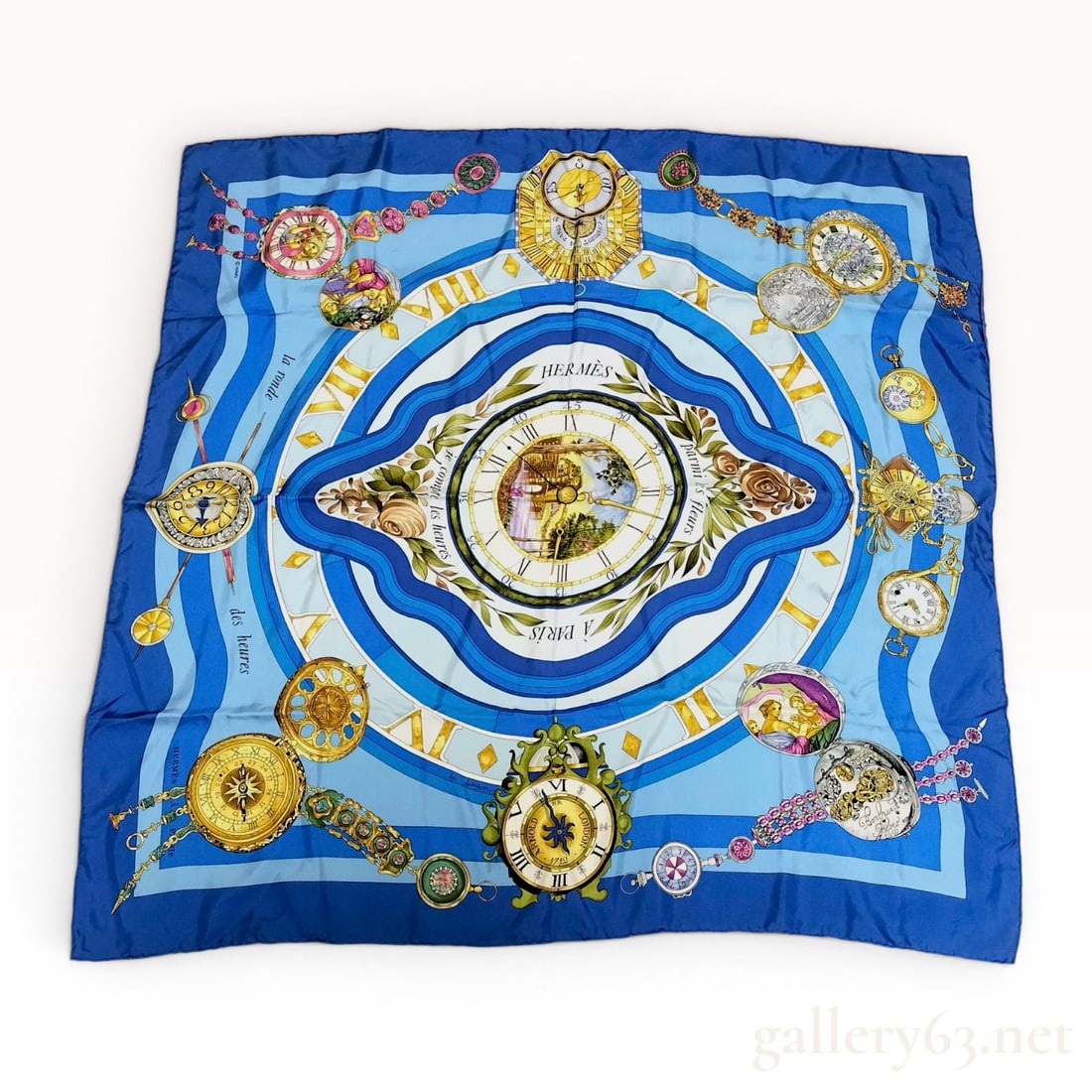Hermes La Ronde des Heures Silk Scarf by Loic Dubigeon: A square 100 percent silk scarf by Hermes featuring the La Ronde des Heures pattern, designed by artist Loic Dubigeon and originally issued in 1986. The design centers on a clock face depicting a past