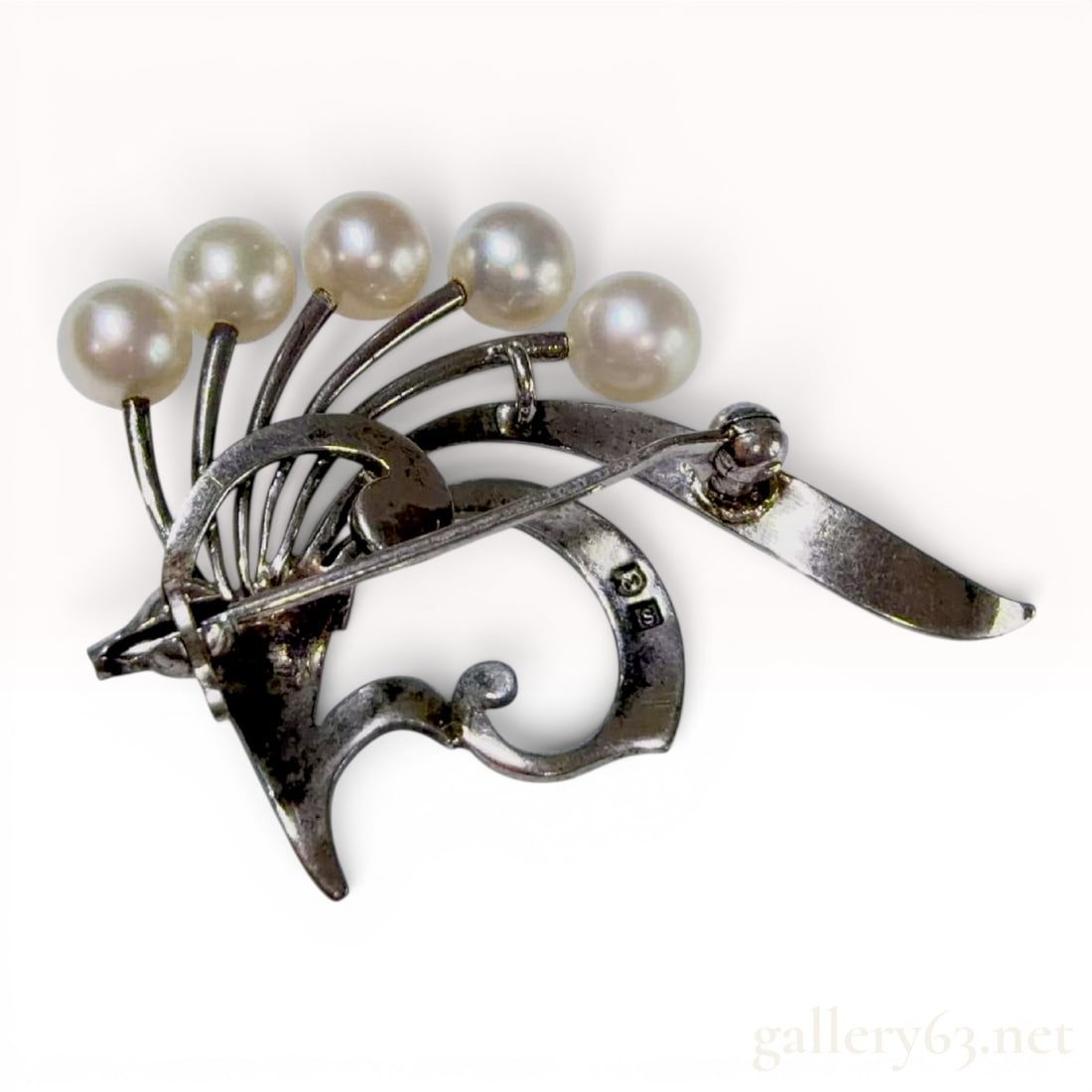Sterling Silver and Five Pearl Foliate Spray Brooch: A sterling silver and cultured pearl spray brooch. The piece is designed as a stylized foliate spray consisting of five graduated curving stems, each terminating in a round white pearl. The main body 