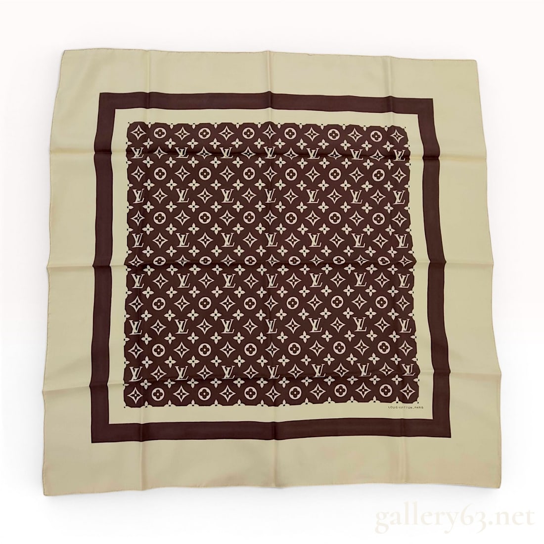 Louis Vuitton Monogram Silk Twill Square Scarf: A square silk scarf by Louis Vuitton featuring the house signature Monogram pattern. The design is centered with a chocolate brown field printed with cream-colored LV initials and floral motifs. The c