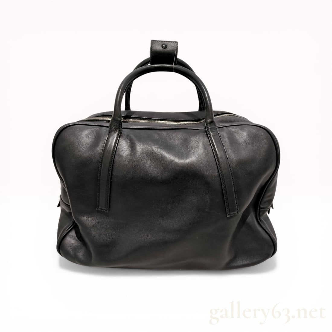 Gucci Black Leather Travel Duffel Weekender Bag: Gucci travel duffel bag in smooth black leather with silver-toned hardware. The construction features dual rolled top handles with a snap-fastening connector, a full-length top zipper, and five square