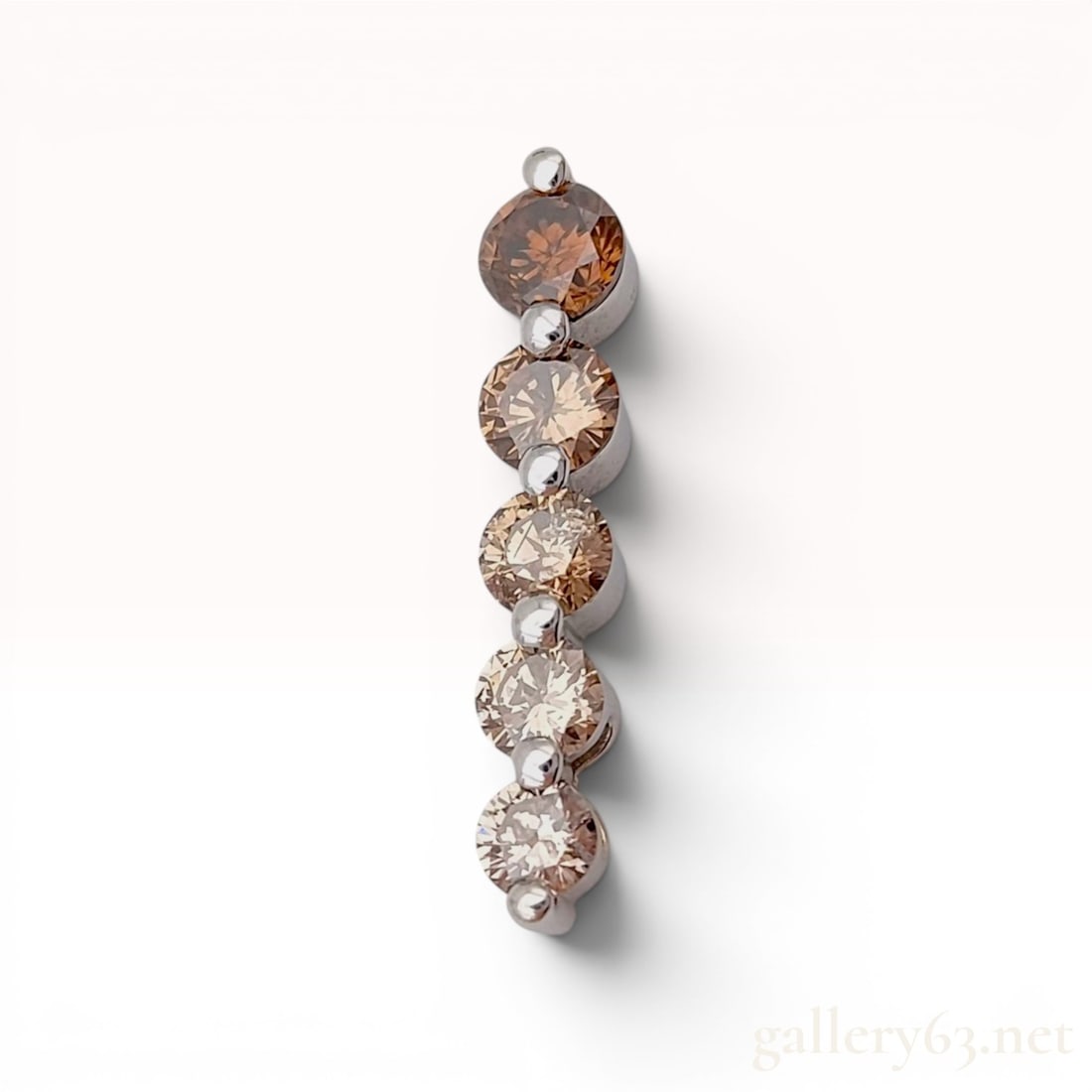 18 Karat White Gold and Graduated Brown Diamond Bar Pendant: This linear bar-style pendant is crafted in 18 karat white gold and features five round brilliant-cut diamonds. The diamonds are graduated in size and color, displaying shades of brown ranging from a 
