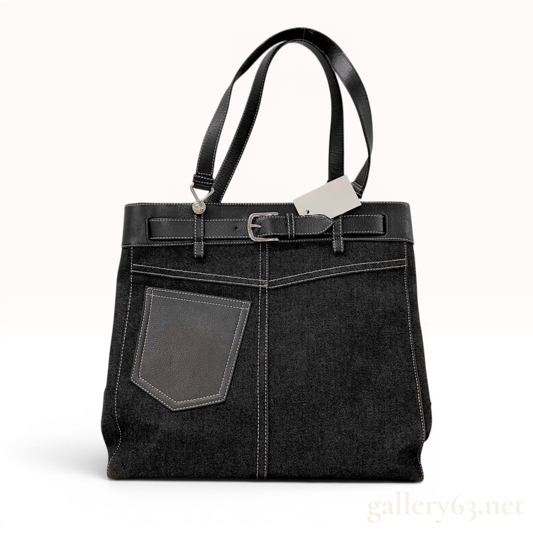 Christian Dior Black Denim and Leather Jeans Pocket Tote Bag: This Christian Dior Jeans Pocket tote bag is constructed from black denim twill with black leather accents and dual flat leather shoulder straps. The front face features a single shield-shaped leather
